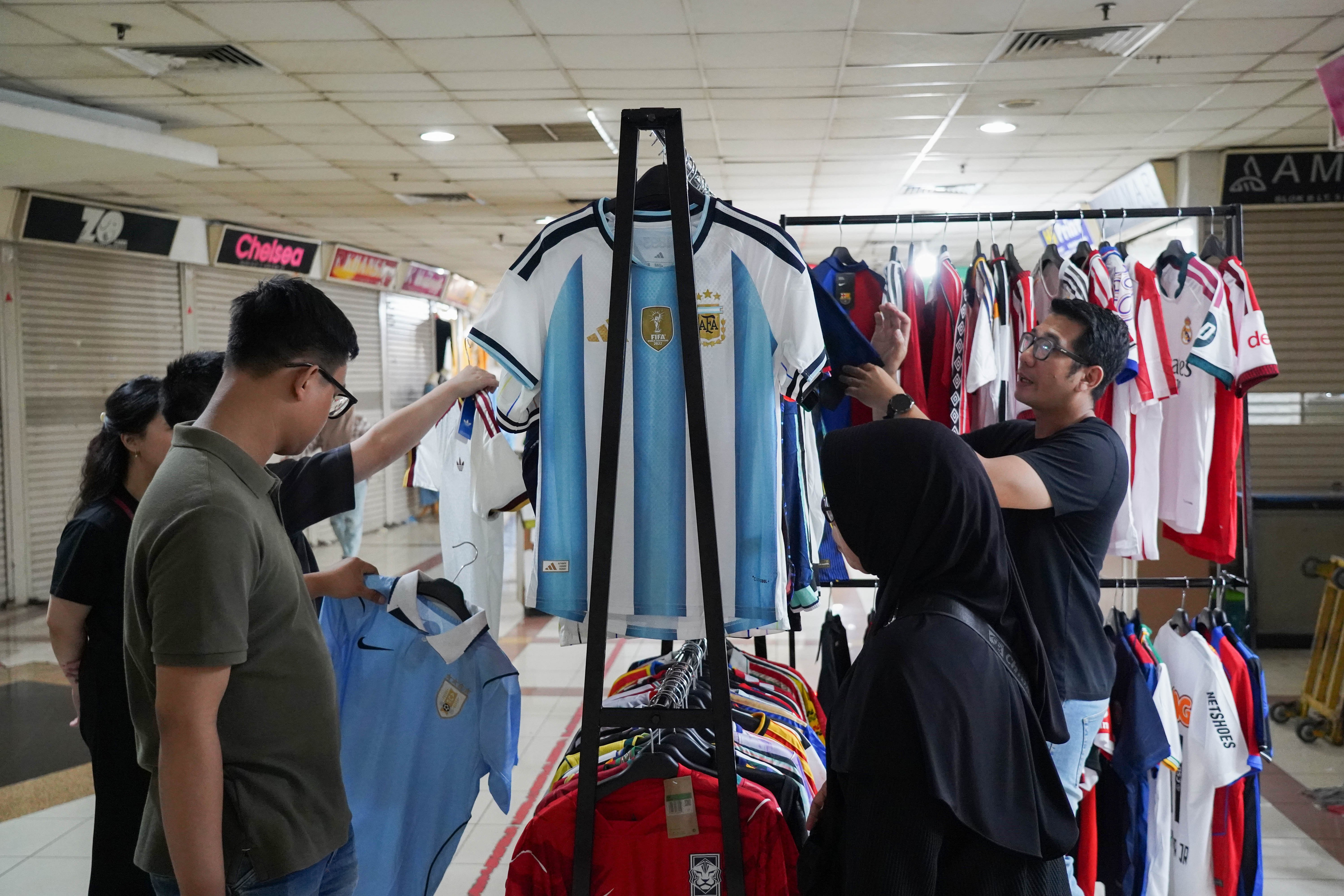 Calon pembeli melihat kaos sepak bola di Pasar Tanah Abang Blok B, Jakarta, Rabu (17/6/2026). Berdasarkan keterangan pedagang, jersi negara peserta Piala Dunia yang dijajakan mulai dari Rp 220 ribu-Rp 270 ribu itu diminati oleh penggemar sepak bola sehingga penjualannya meningkat.