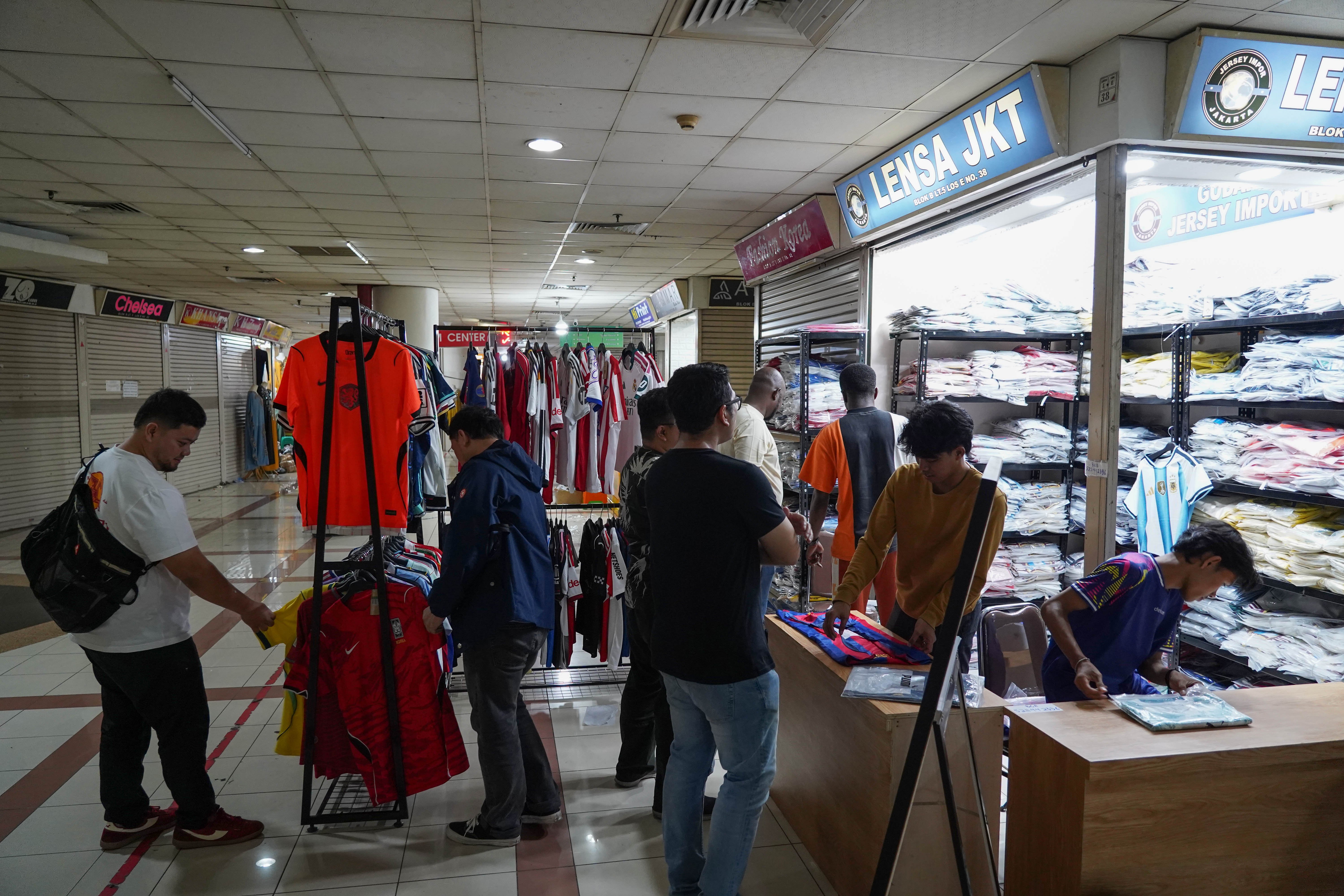Calon pembeli melihat kaos sepak bola di Pasar Tanah Abang Blok B, Jakarta, Rabu (17/6/2026). Berdasarkan keterangan pedagang, jersi negara peserta Piala Dunia yang dijajakan mulai dari Rp 220 ribu-Rp 270 ribu itu diminati oleh penggemar sepak bola sehingga penjualannya meningkat.