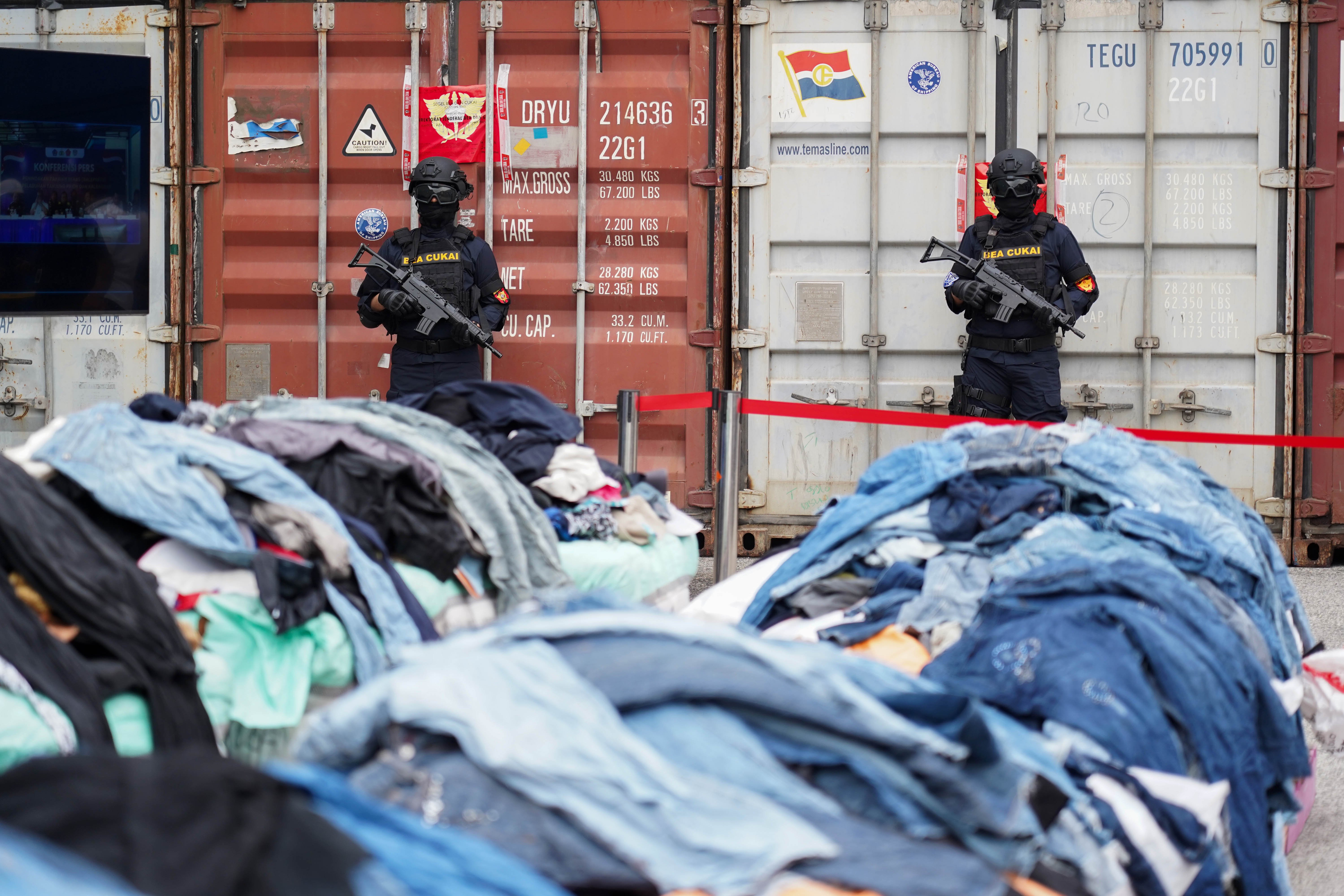 Petugas berjaga di depan kontainer yang berisi barang bukti pakaian bekas impor ilegal saat konferensi pers di Buffer Area TPS CDC Pelabuhan Tanjung Priok, Jakarta, Selasa (23/6/2026). Direktorat Jenderal Bea dan Cukai Kementerian Keuangan mengungkap peredaran pakaian bekas impor ilegal di Pelabuhan Tanjung Priok dengan mengamankan 43 kontainer berisi 4.687 bale dan menyita 2.060 bale lainnya di Kalimantan Barat dengan total nilai ekonomi barang mencapai sekitar Rp 53,08 miliar.