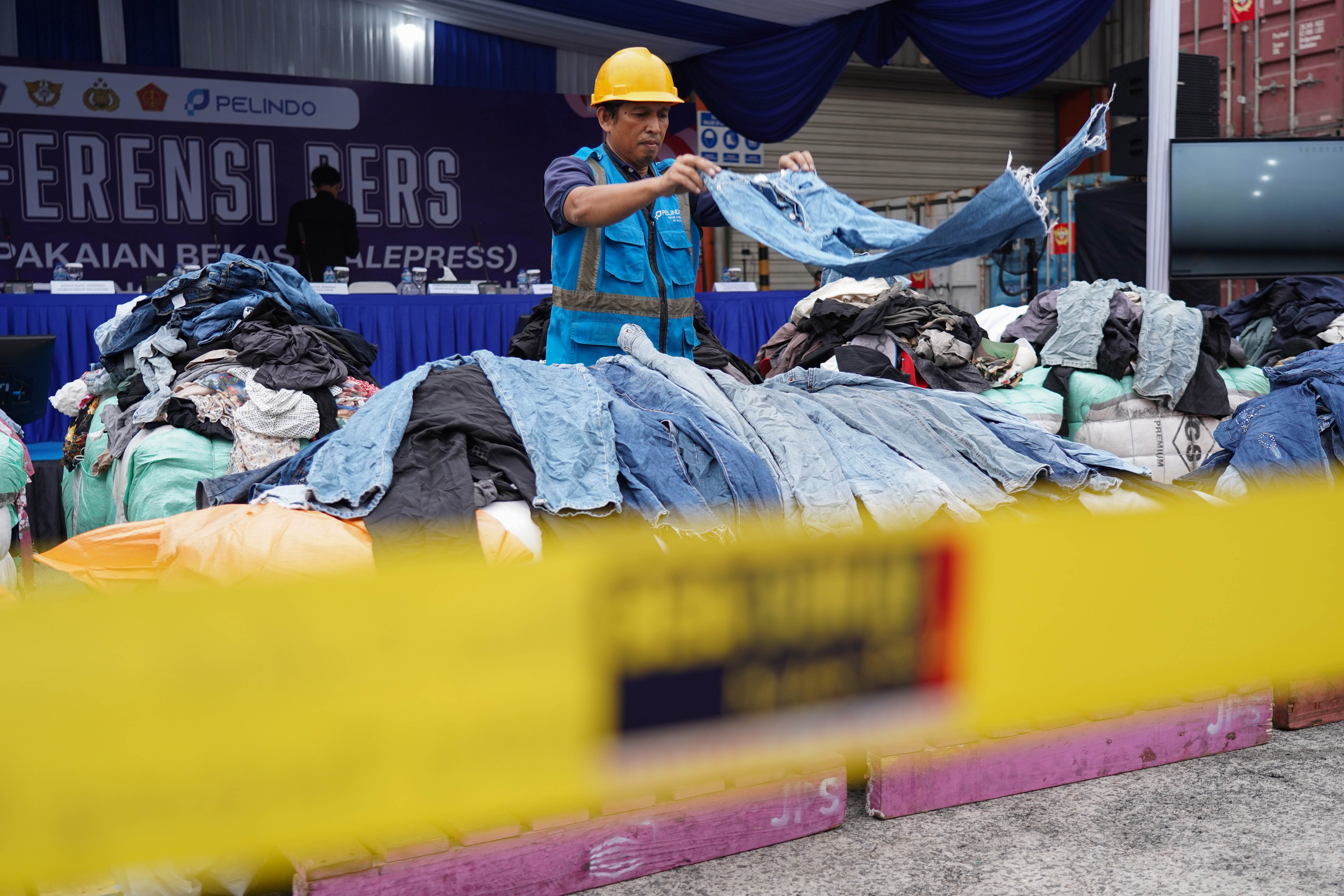 Petugas menata barang bukti pakaian bekas impor ilegal saat konferensi pers di Buffer Area TPS CDC Pelabuhan Tanjung Priok, Jakarta, Selasa (23/6/2026). Direktorat Jenderal Bea dan Cukai Kementerian Keuangan mengungkap peredaran pakaian bekas impor ilegal di Pelabuhan Tanjung Priok dengan mengamankan 43 kontainer berisi 4.687 bale dan menyita 2.060 bale lainnya di Kalimantan Barat dengan total nilai ekonomi barang mencapai sekitar Rp 53,08 miliar.