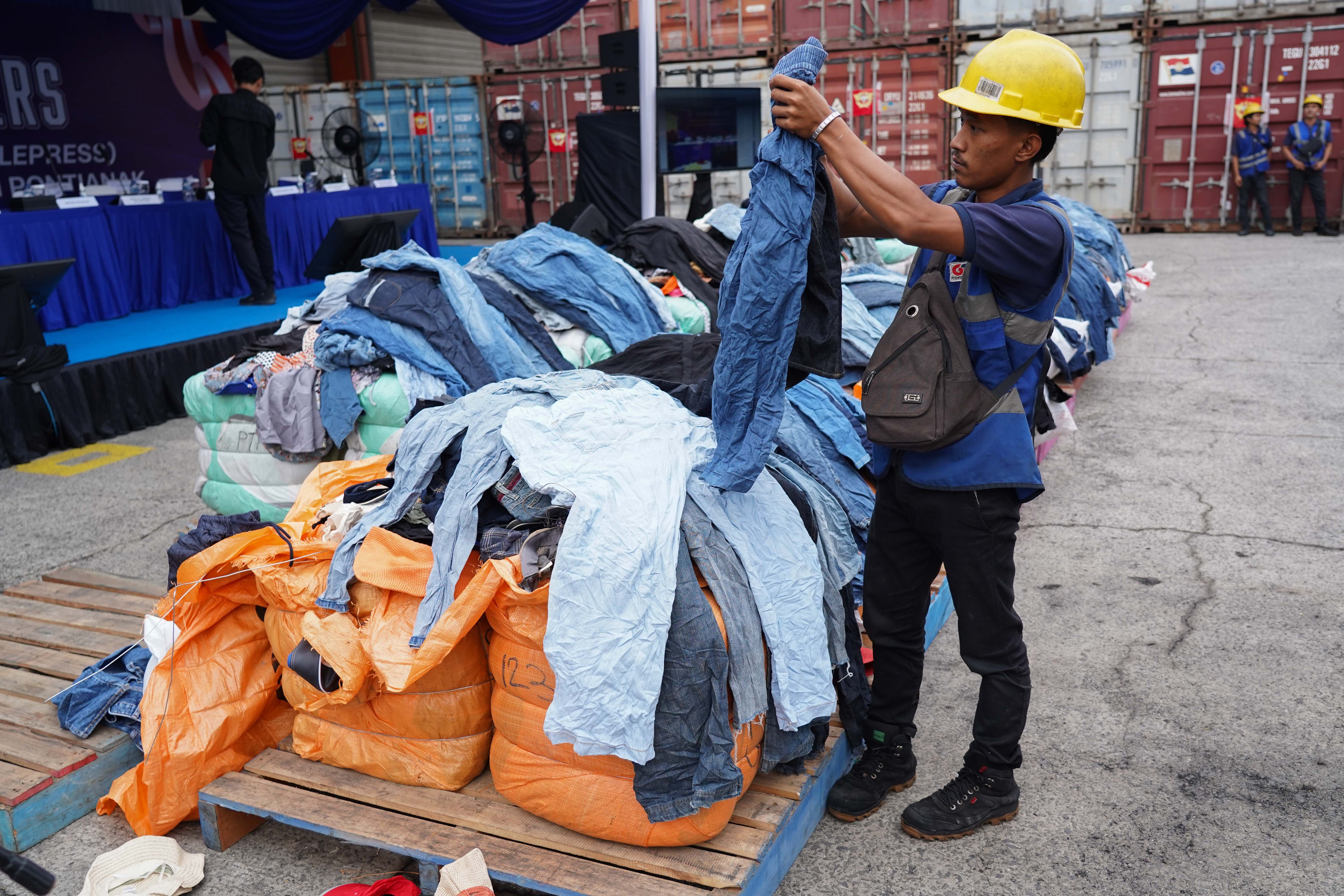 Petugas menata barang bukti pakaian bekas impor ilegal saat konferensi pers di Buffer Area TPS CDC Pelabuhan Tanjung Priok, Jakarta, Selasa (23/6/2026). Direktorat Jenderal Bea dan Cukai Kementerian Keuangan mengungkap peredaran pakaian bekas impor ilegal di Pelabuhan Tanjung Priok dengan mengamankan 43 kontainer berisi 4.687 bale dan menyita 2.060 bale lainnya di Kalimantan Barat dengan total nilai ekonomi barang mencapai sekitar Rp 53,08 miliar.