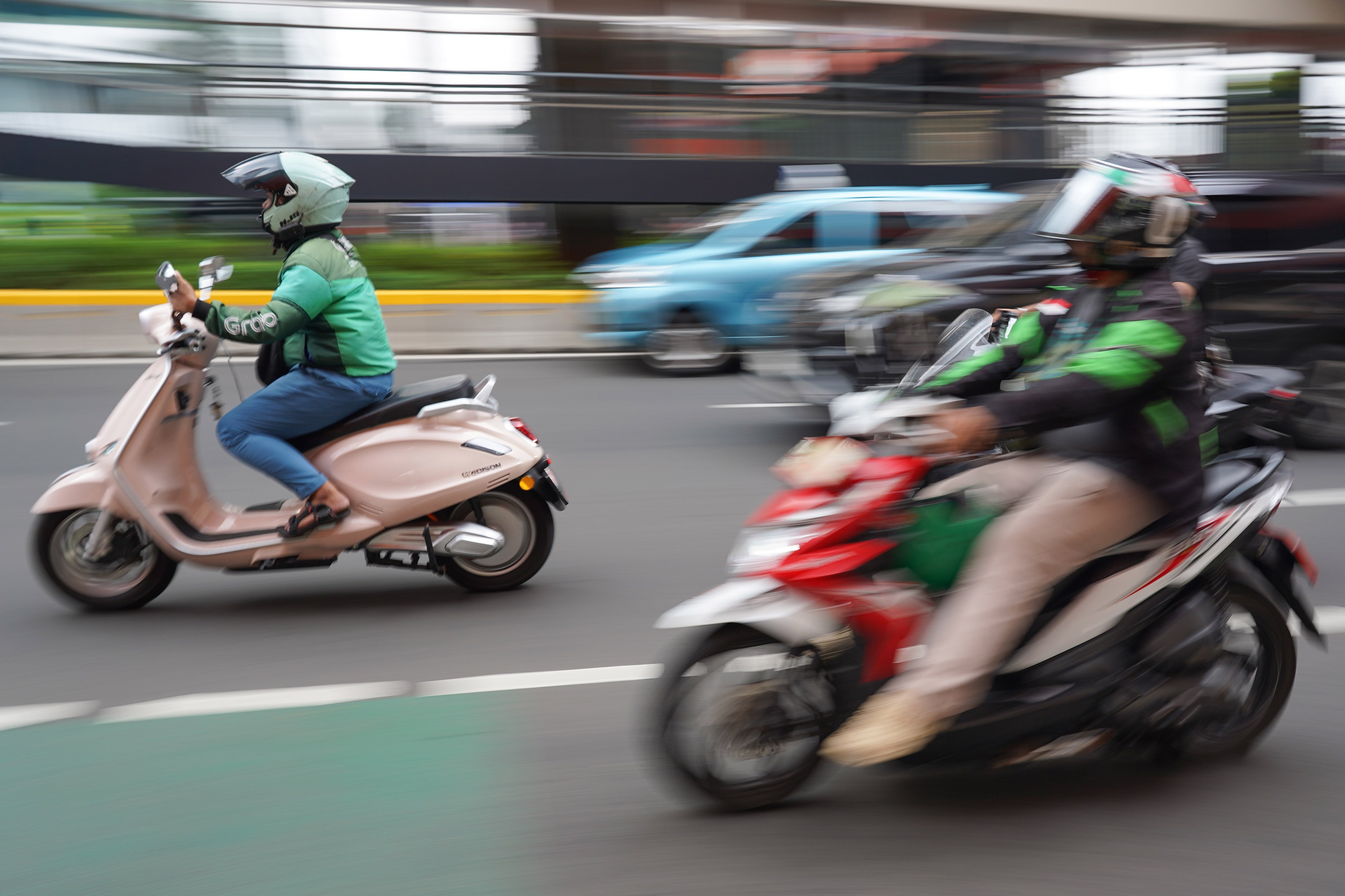Pengemudi ojek online atau ojol melintas di Jalan HR Rasuna Said, Kuningan, Jakarta, Kamis (25/6/2026). Dua aplikator transportasi daring, Grab dan Gojek secara resmi telah menyatakan akan menerapkan potongan komisi 8% kepada mitra pengemudi transportasi roda dua mulai 1 Juli 2026 yang sesuai Peraturan Presiden (Perpres) Nomor 27 Tahun 2026 tentang Perlindungan Pekerja Transportasi Online.