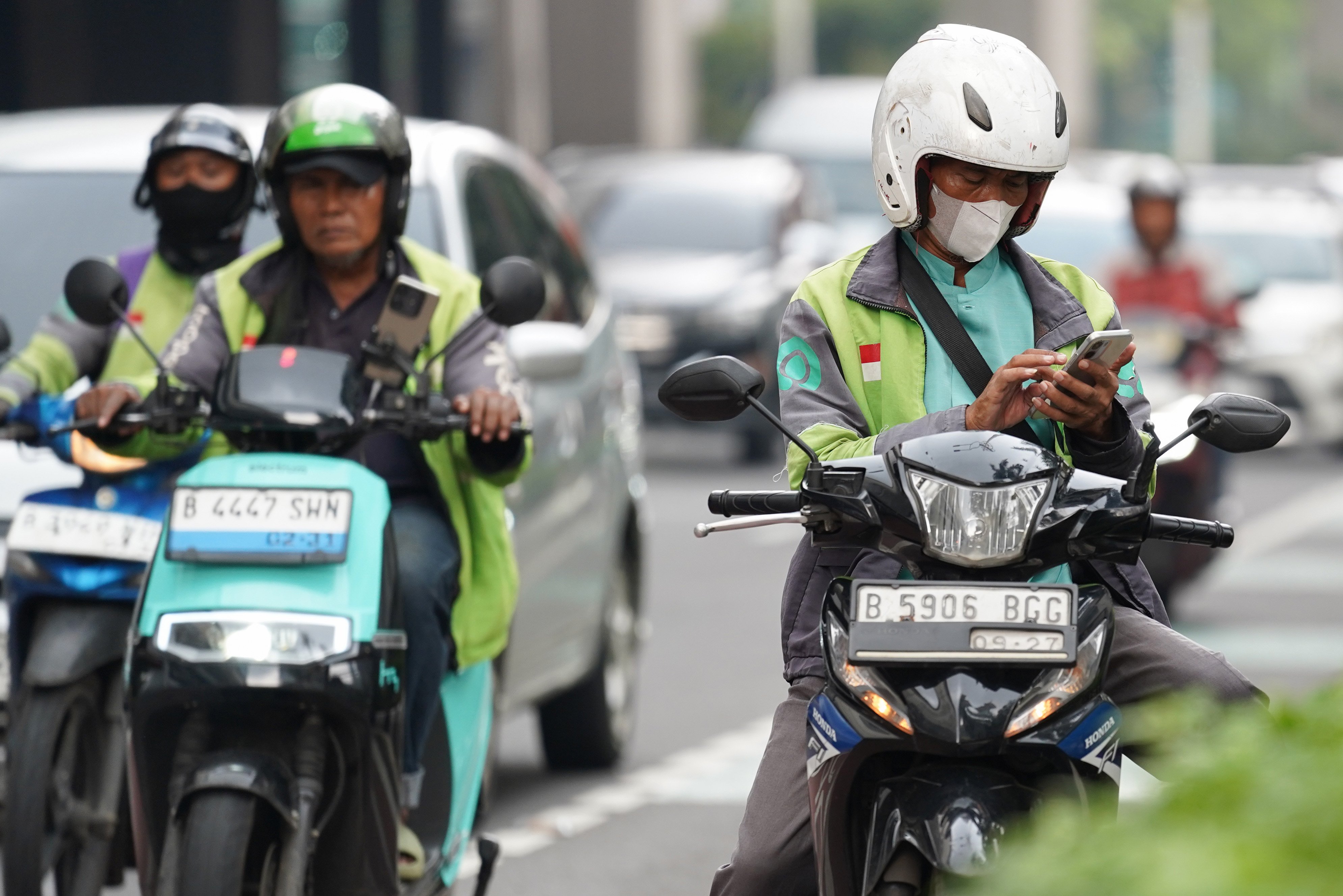 Pengemudi ojek online atau ojol menunggu pesanan di Jalan HR Rasuna Said, Kuningan, Jakarta, Kamis (25/6/2026). Dua aplikator transportasi daring, Grab dan Gojek secara resmi telah menyatakan akan menerapkan potongan komisi 8% kepada mitra pengemudi transportasi roda dua mulai 1 Juli 2026 yang sesuai Peraturan Presiden (Perpres) Nomor 27 Tahun 2026 tentang Perlindungan Pekerja Transportasi Online.