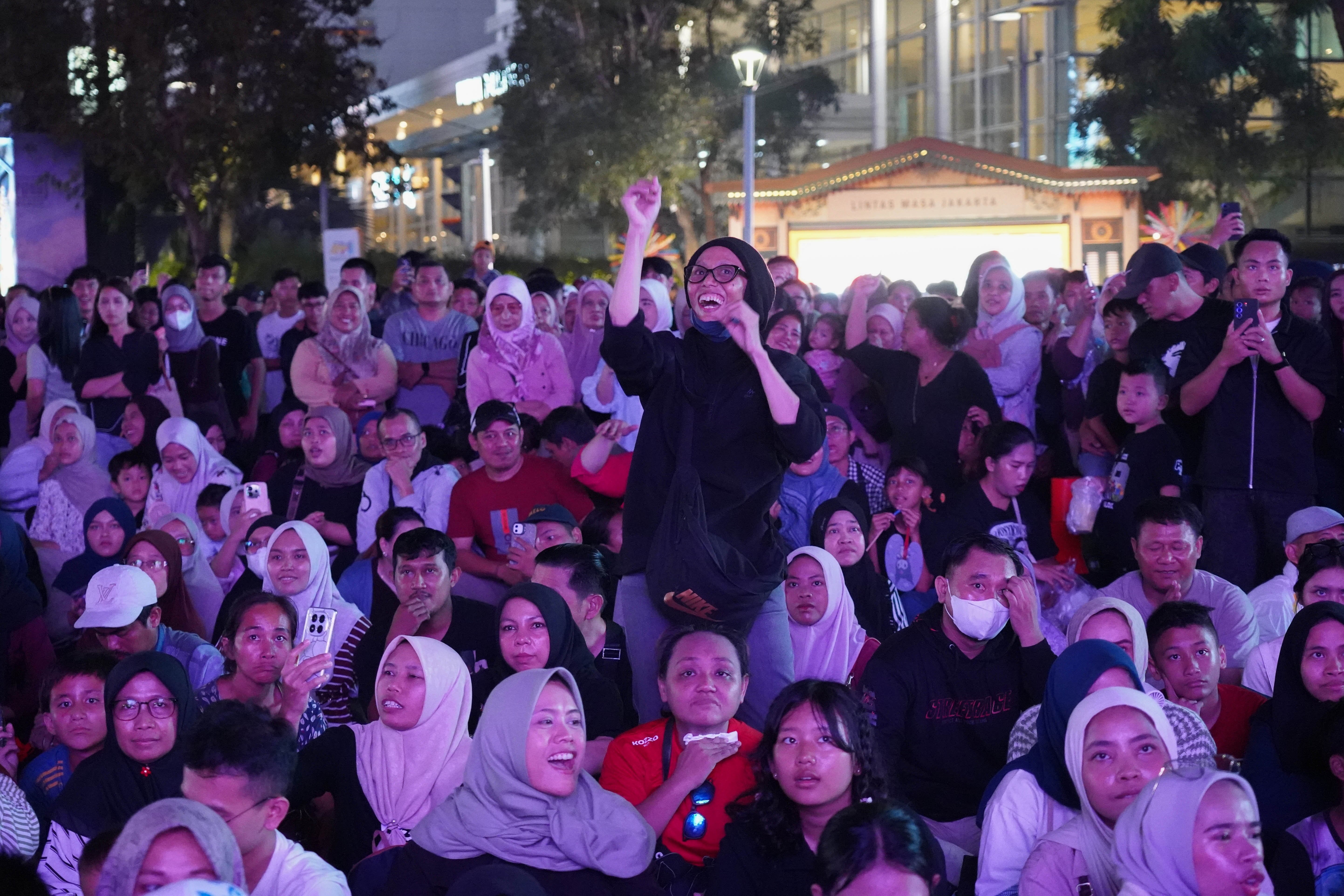 Warga bernyanyi saat menyaksikan pertunjukkan musik pada malam puncak HUT ke-499 Kota Jakarta di kawasan Bundaran HI, Sabtu (27/6/2026). Acara tersebut dimeriahkan berbagai pertunjukkan mulai dari video mapping, instalasi seni, atraksi pencahayaan hingga panggung hiburan yang menampilkan konser musik dari musisi papan atas.