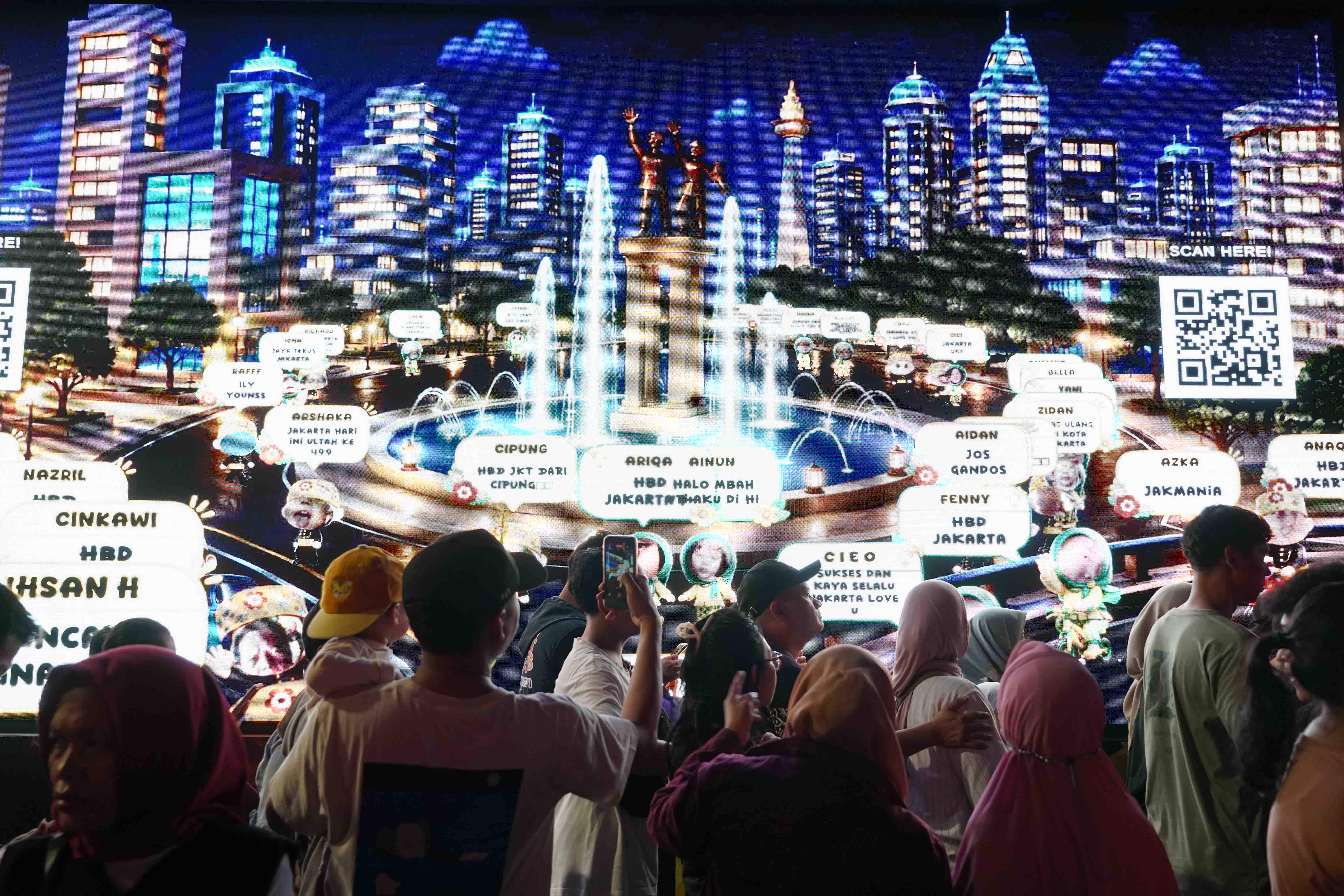 Warga melihat layar yang menampilkan animasi kota pada malam puncak HUT ke-499 Jakarta di kawasan Bundaran HI, Sabtu (27/6/2026). Acara tersebut dimeriahkan berbagai pertunjukkan mulai dari video mapping, instalasi seni, atraksi pencahayaan hingga panggung hiburan yang menampilkan konser musik dari musisi papan atas.