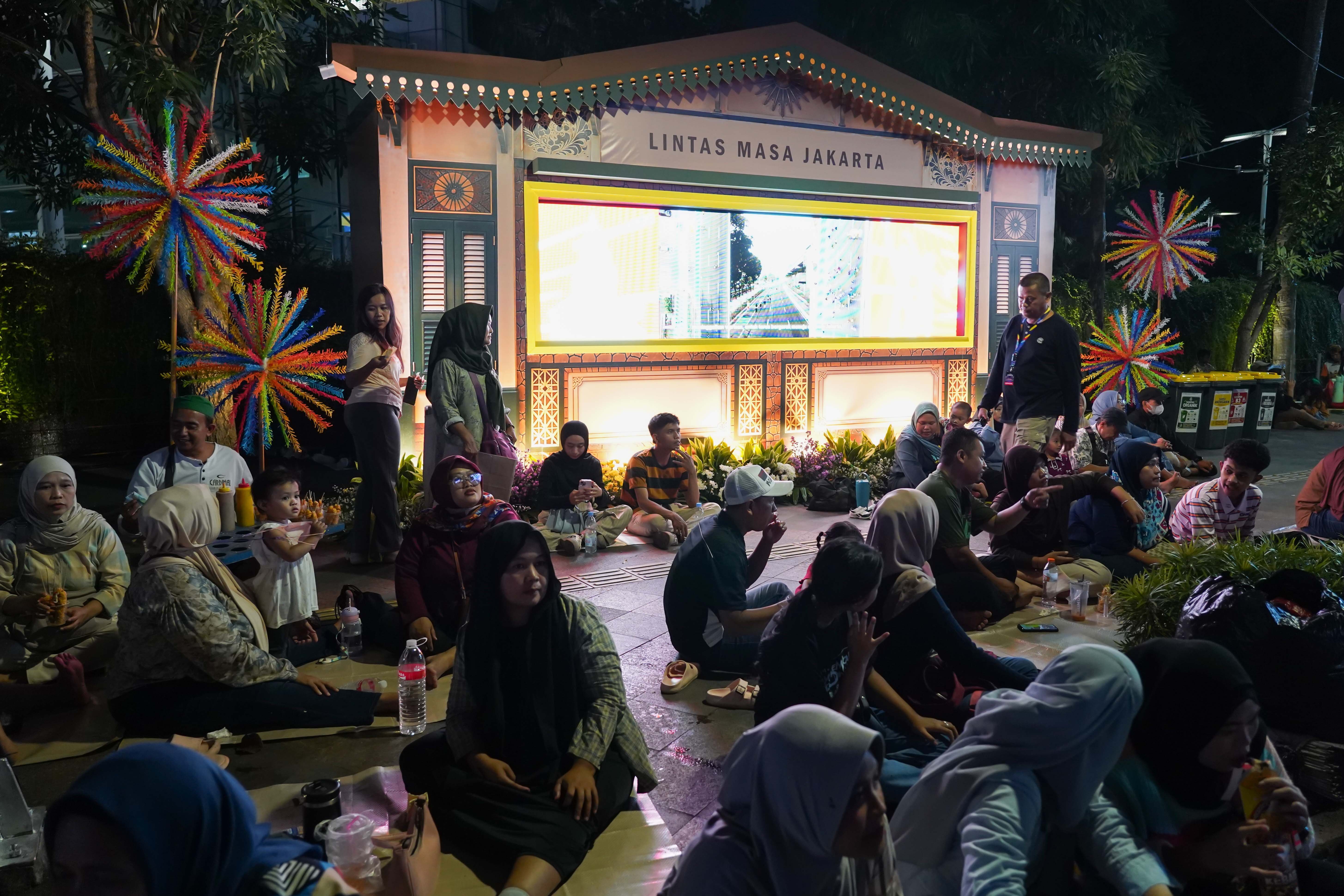 Warga menghadiri malam puncak HUT ke-499 Kota Jakarta di kawasan Bundaran HI, Sabtu (27/6/2026). Acara tersebut dimeriahkan berbagai pertunjukkan mulai dari video mapping, instalasi seni, atraksi pencahayaan hingga panggung hiburan yang menampilkan konser musik dari musisi papan atas.