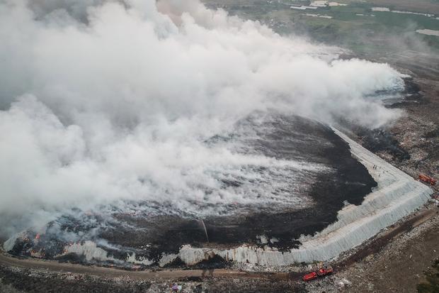 Foto udara petugas pemadam kebakaran berusaha memadamkan api di Tempat Pembuangan Akhir (TPA) Jatiwaringin, Kabupaten Tangerang, Banten, Selasa (30/6/2026). BPBD Kabupaten Tangerang mengerahkan sembilan unit mobil dan 45 personel untuk memadamkan kebakaran yang diperkirakan mencapai seluas dua hektare dan penyebabnya masih dalam penyelidikan karena proses pemadaman masih berlangsung.