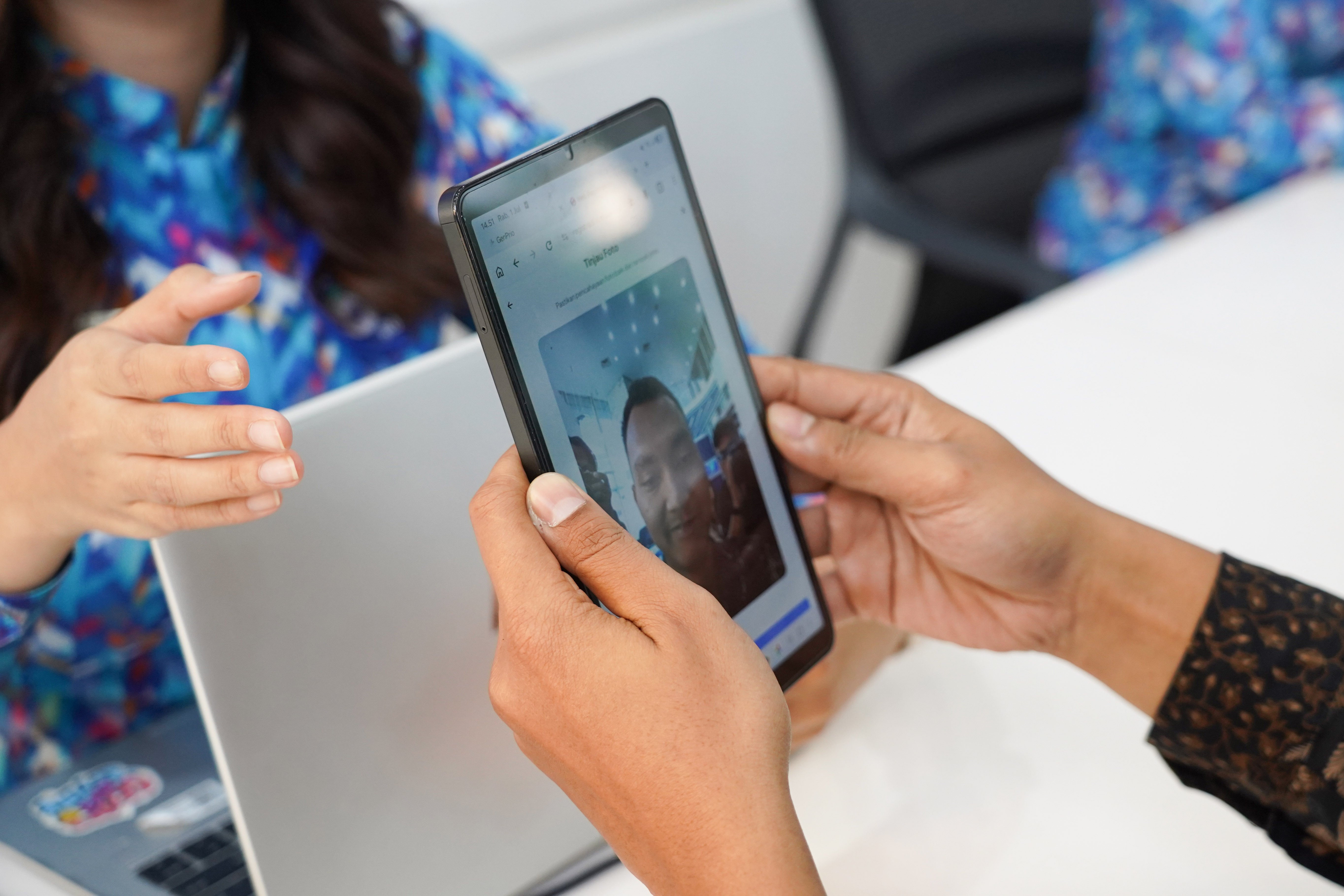 Warga memindai wajahnya saat mengurus verifikasi kartu SIM baru di kantor operator seluler XL Axiata, Jakarta, Rabu (1/7). Kementerian Komunikasi dan Digital (Komdigi) memberlakukan kebijakan registrasi biometrik menggunakan teknologi pengenalan wajah untuk nomor seluler baru mulai 1 Juli 2026 guna memperkuat perlindungan masyarakat dari penipuan digital dan penyalahgunaan identitas dalam registrasi kartu SIM telepon seluler.