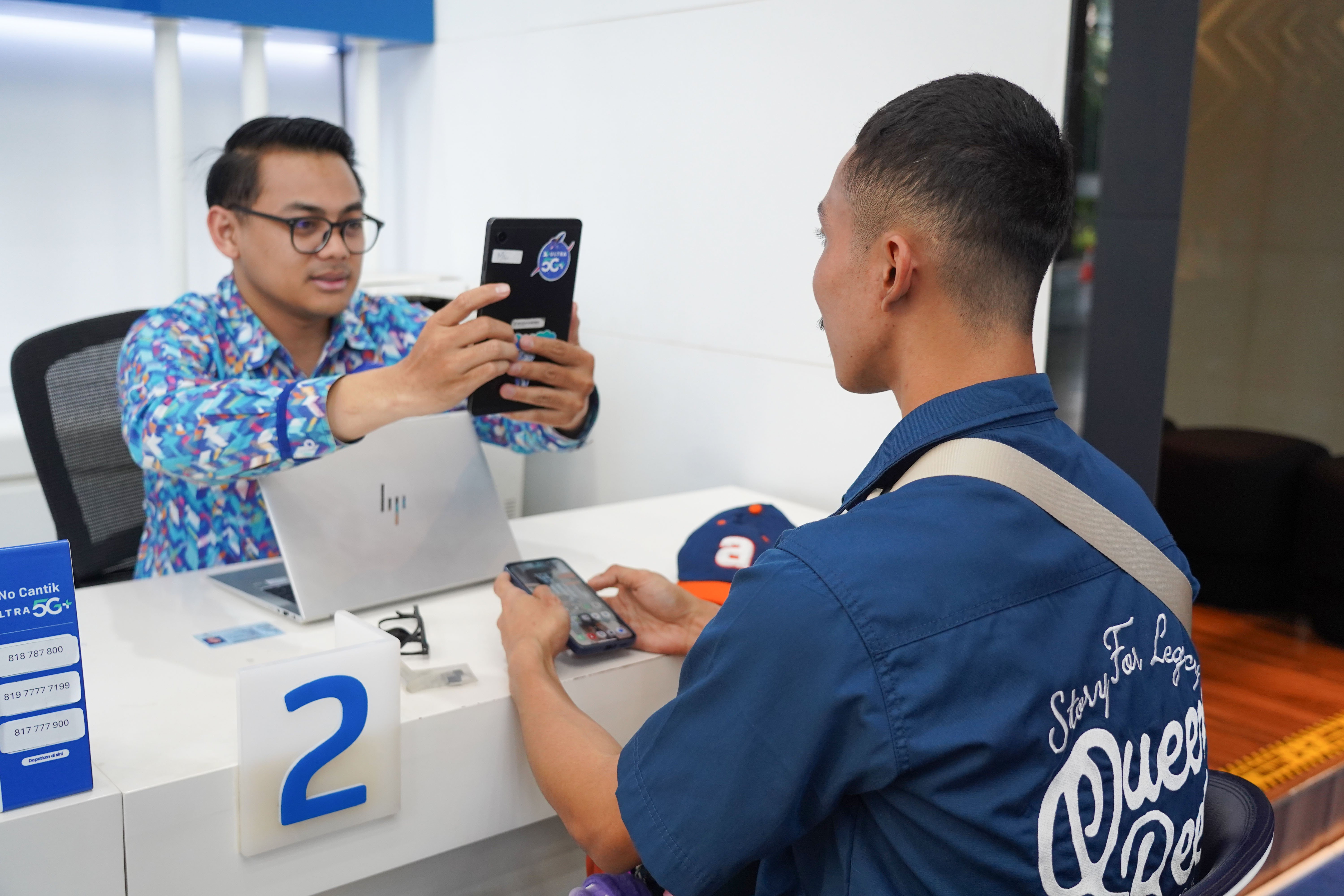 Petugas melayani warga yang mengurus verifikasi kartu SIM baru di kantor operator seluler XL Axiata, Jakarta, Rabu (1/7). Kementerian Komunikasi dan Digital (Komdigi) memberlakukan kebijakan registrasi biometrik menggunakan teknologi pengenalan wajah untuk nomor seluler baru mulai 1 Juli 2026 guna memperkuat perlindungan masyarakat dari penipuan digital dan penyalahgunaan identitas dalam registrasi kartu SIM telepon seluler.