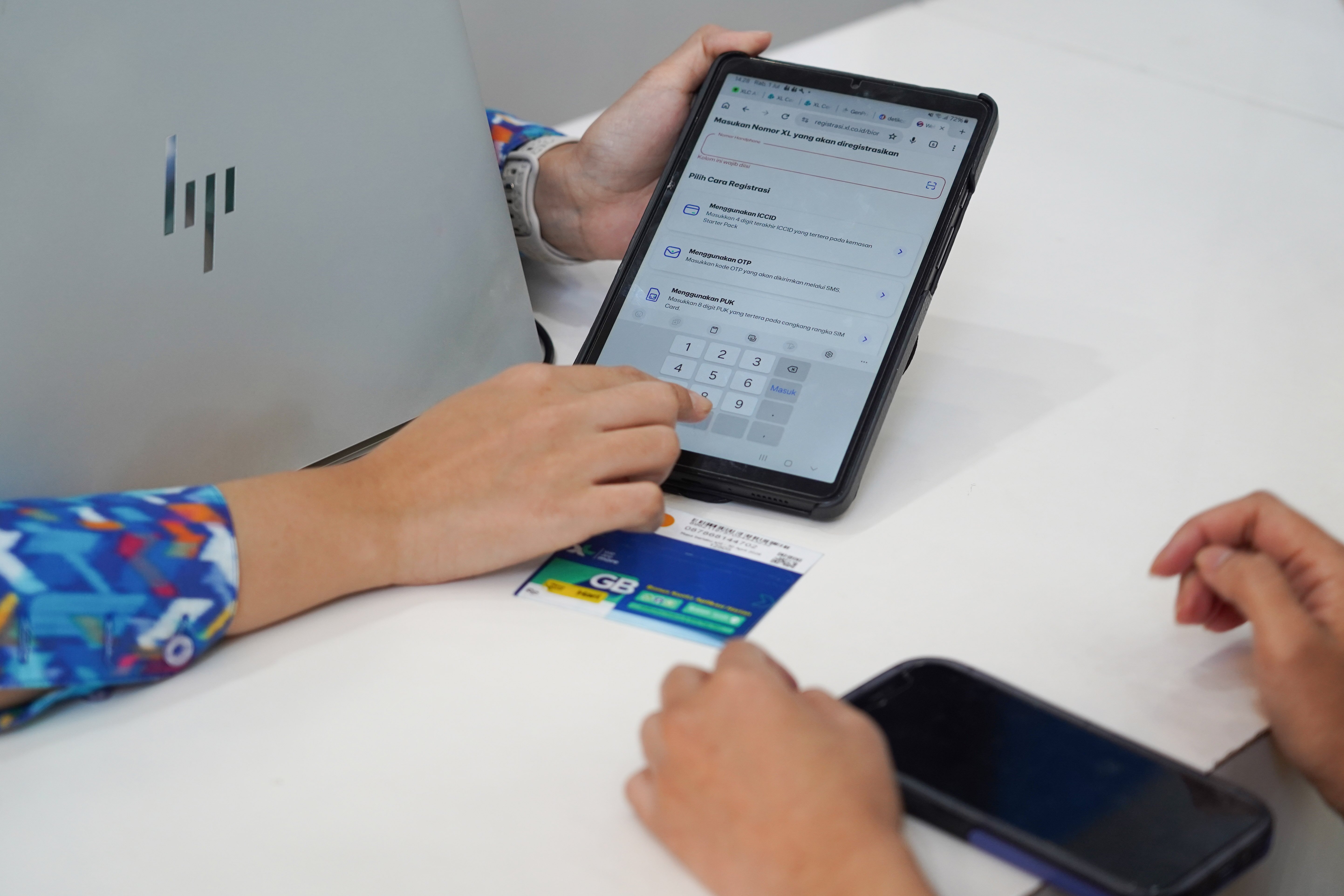 Petugas melayani warga yang mengurus verifikasi kartu SIM baru di kantor operator seluler XL Axiata, Jakarta, Rabu (1/7). Kementerian Komunikasi dan Digital (Komdigi) memberlakukan kebijakan registrasi biometrik menggunakan teknologi pengenalan wajah untuk nomor seluler baru mulai 1 Juli 2026 guna memperkuat perlindungan masyarakat dari penipuan digital dan penyalahgunaan identitas dalam registrasi kartu SIM telepon seluler.
