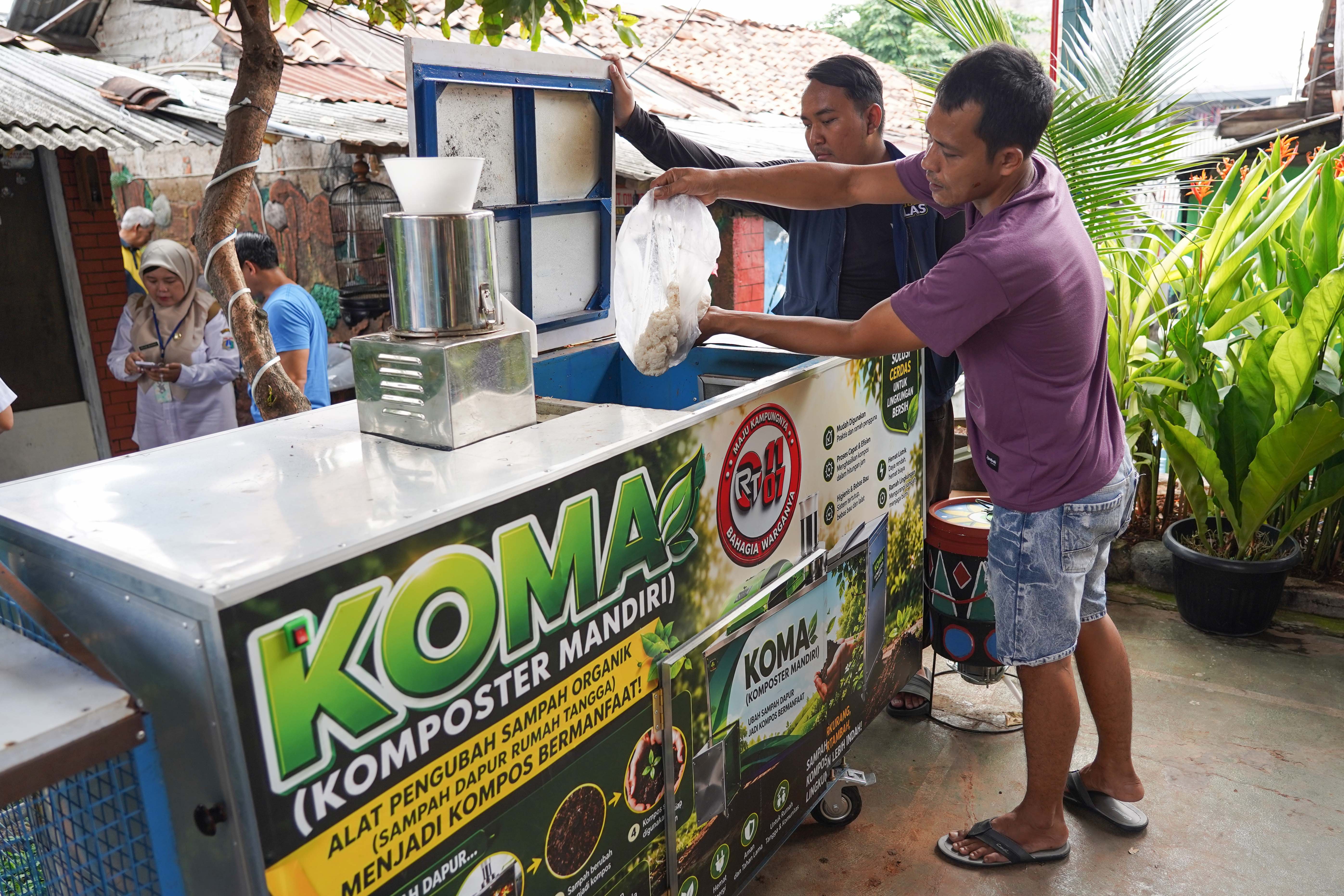 Warga menyetorkan sampah kepada petugas untuk didaur ulang menggunakan mesin komposter di kawasan RT 11/RW 07, Gandaria Utara, Kebayoran Baru, Jakarta Selatan, Rabu (8/7/2026). Mesin yang dibuat secara mandiri oleh warga di lingkungan tersebut mampu mengolah sampah organik menjadi pupuk kompos sehingga dapat mengurangi sampah langsung dari sumbernya.