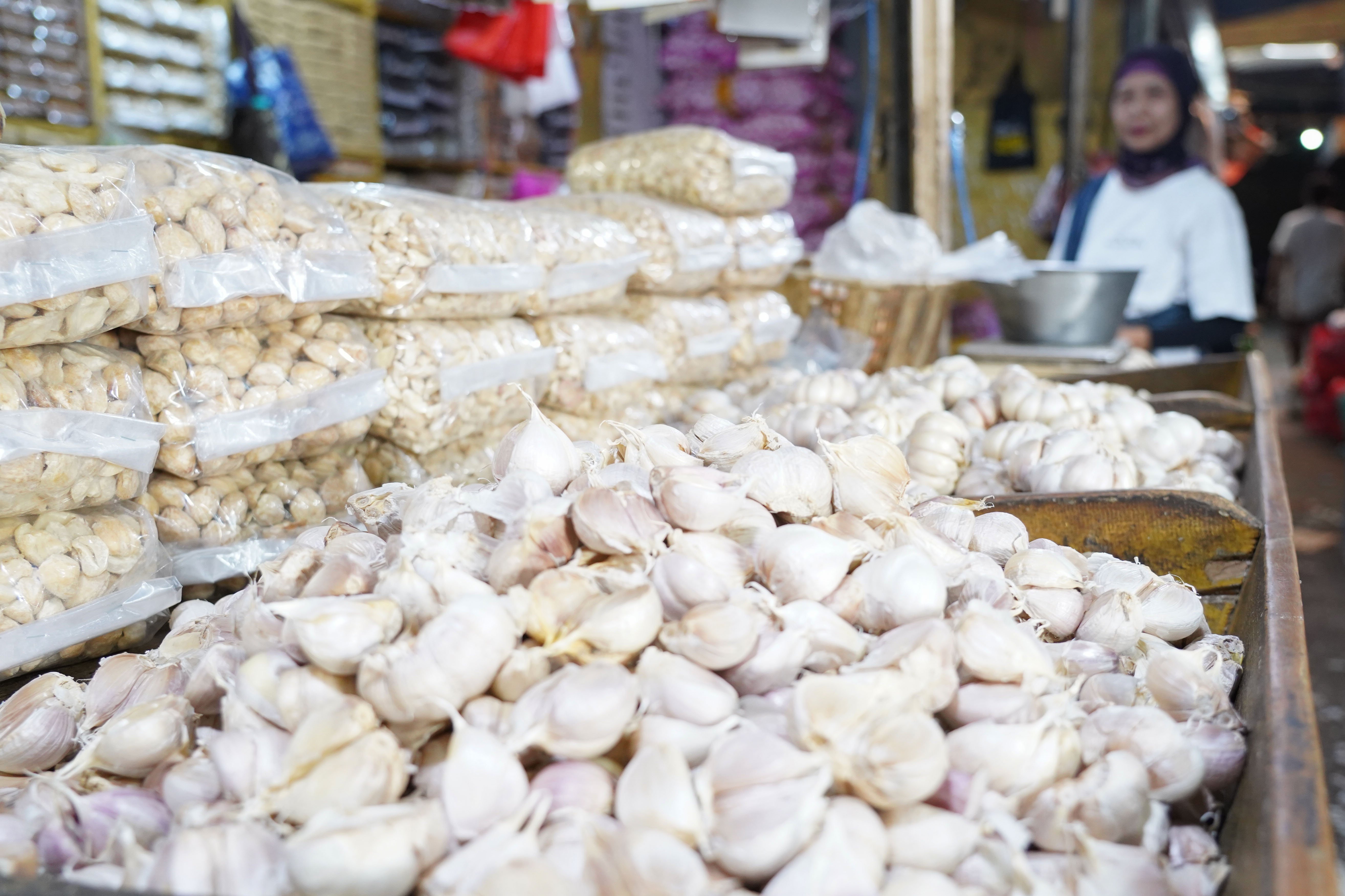 Calon pembeli melihat bawang putih impor yang dijual di Pasar Induk Kramat Jati, Jakarta, Selasa (14/7/2026). Berdasarkan pemantauan Indeks Perkembangan Harga (IPH), rata-rata harga bawang putih secara nasional kini mencapai Rp 42.611 per kilogram atau sudah berada jauh di atas Harga Acuan Penjualan (HAP) konsumen. Kenaikan ini disebabkan oleh melemahnya nilai tukar rupiah terhadap dolar Amerika Serikat (AS) dan meningkatnya biaya logistik internasional.