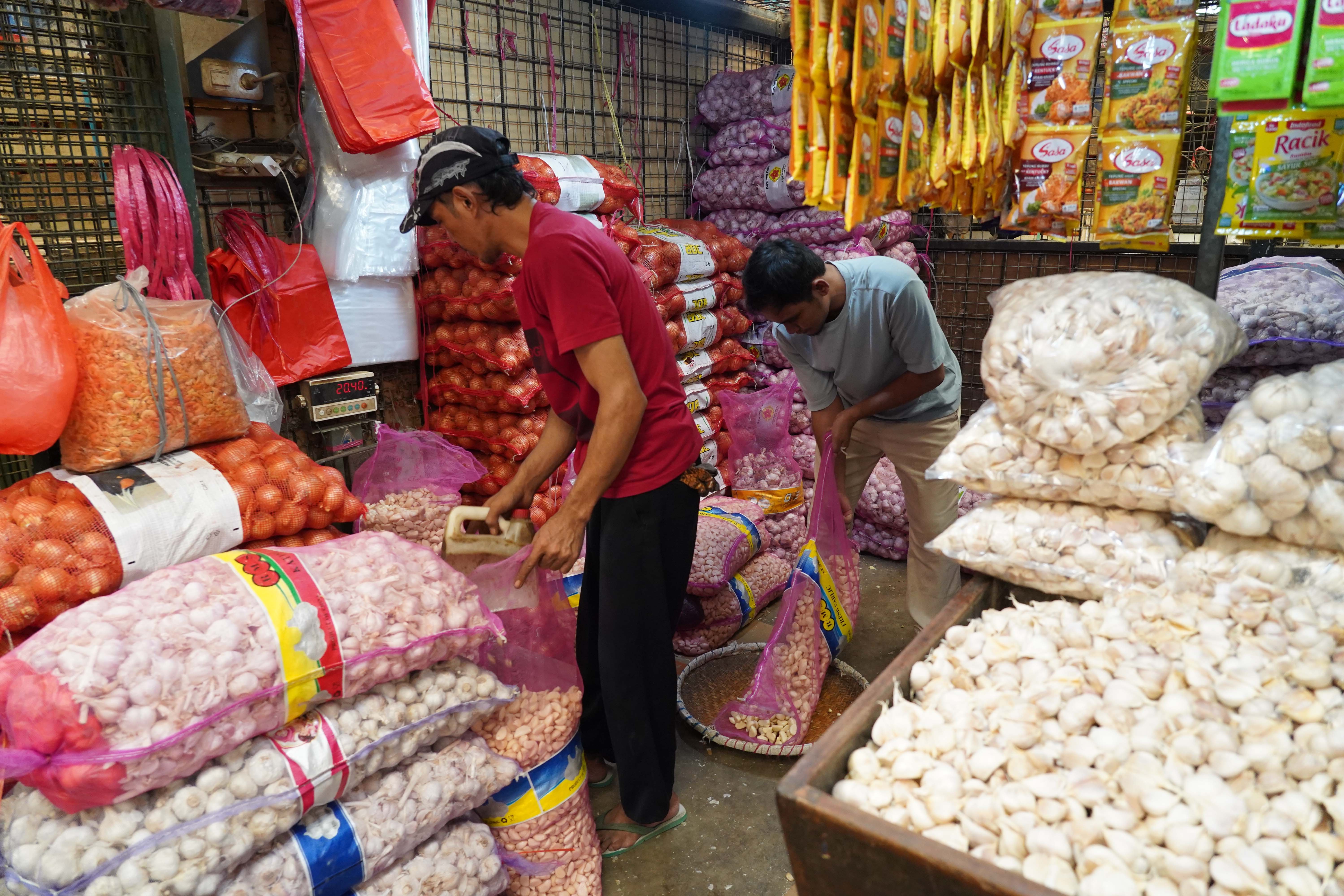 Pedagang mengemas bawang putih impor yang dijual di Pasar Induk Kramat Jati, Jakarta, Selasa (14/7/2026). Berdasarkan pemantauan Indeks Perkembangan Harga (IPH), rata-rata harga bawang putih secara nasional kini mencapai Rp 42.611 per kilogram atau sudah berada jauh di atas Harga Acuan Penjualan (HAP) konsumen. Kenaikan ini disebabkan oleh melemahnya nilai tukar rupiah terhadap dolar Amerika Serikat (AS) dan meningkatnya biaya logistik internasional.