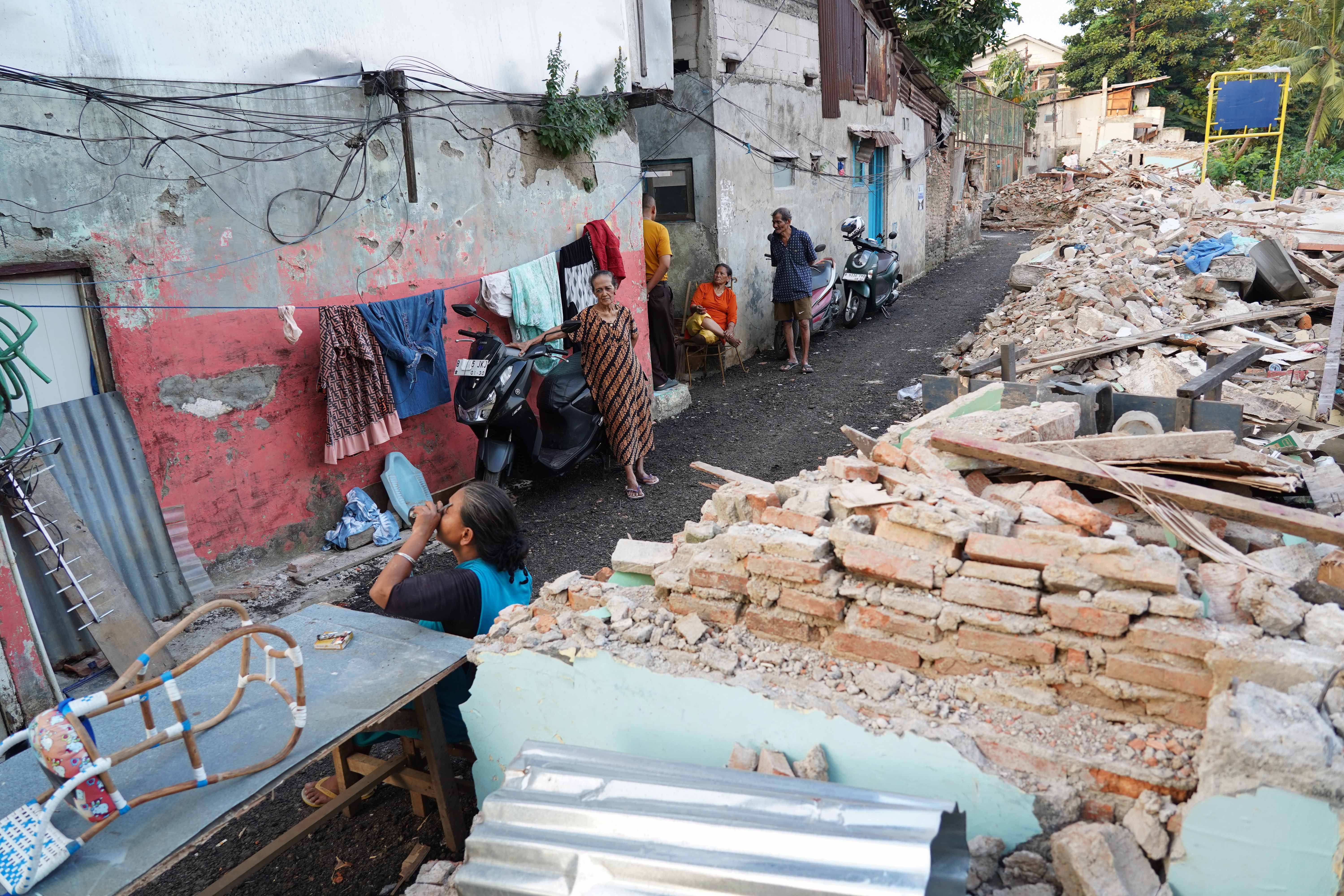 Sejumlah warga berbincang di kawasan yang terdampak proyek normalisasi Kali Ciliwung di Cawang, Kramat Jati, Jakarta Timur, Selasa (14/7/2026). Gubernur Pramono Anung menyebut dari total 170 rumah warga yang terdampak pembebasan lahan untuk normalisasi kali Ciliwung, sebanyak 62 rumah telah rampung pembayaran dan sudah dibongkar, sementara 108 rumah sisanya ditargetkan akan selesai pada akhir tahun 2026.