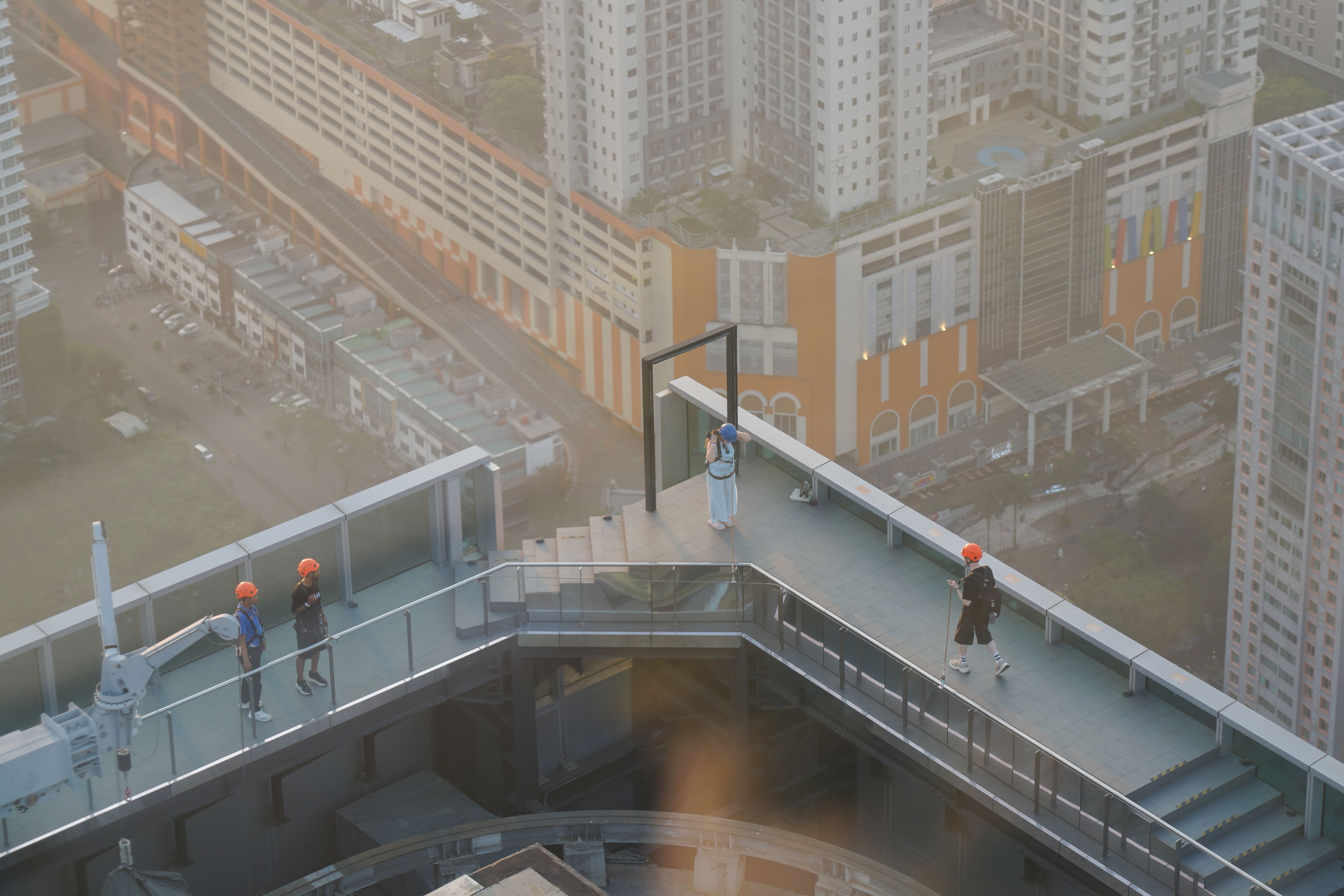 Warga berjalan di tepi gedung pada wahana Upside saat berkunjung ke Sky Garden UP at Thamrin Nine di Autograph Tower, Jakarta Pusat, Rabu (15/7/2026). Objek wisata tersebut menawarkan tempat untuk menikmati suasana panorama Kota Jakarta dari atas gedung tertinggi di Indonesia dengan ketinggian 385 meter.