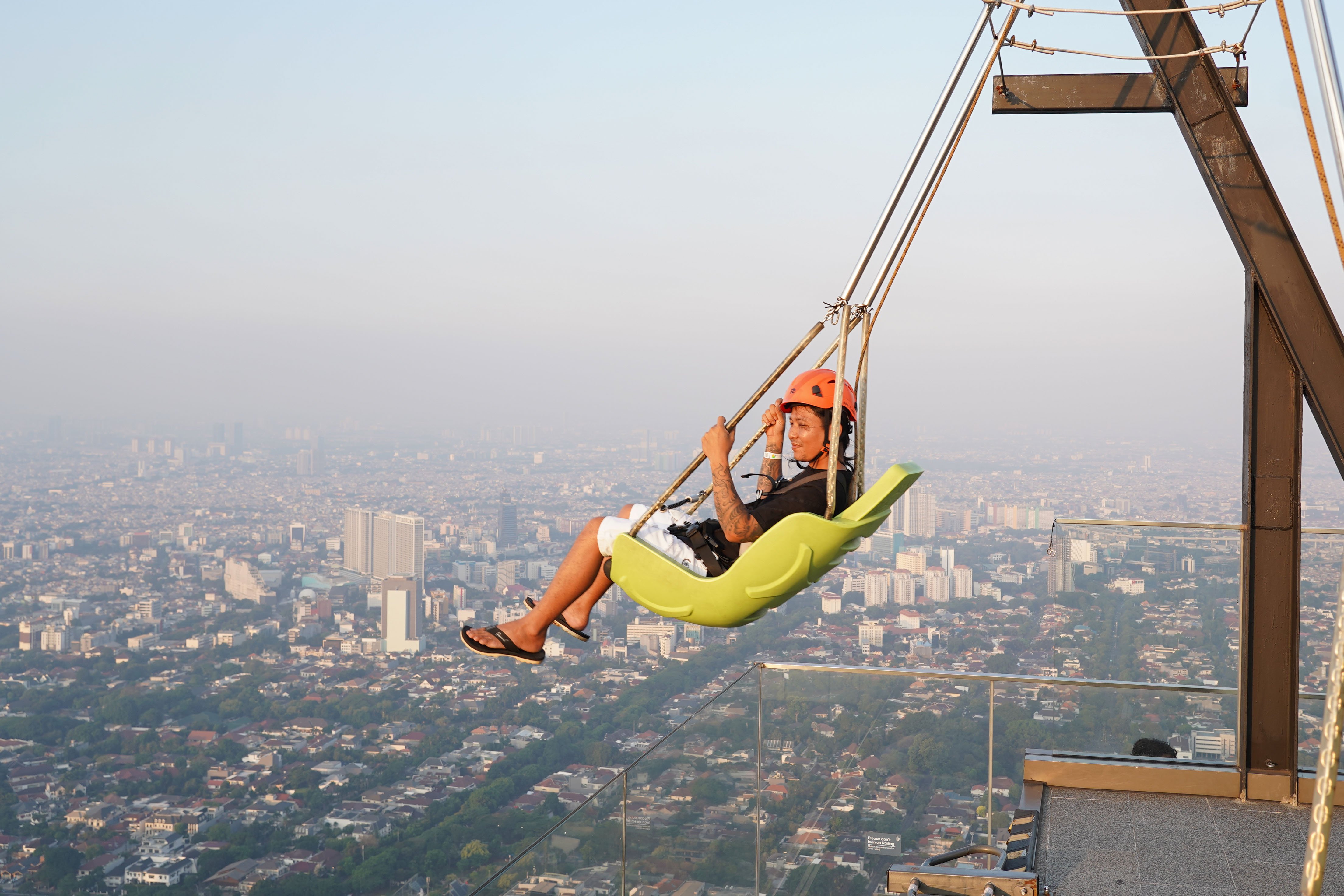 Warga menaiki wahana ayunan Upswing saat berkunjung ke Sky Garden UP at Thamrin Nine di Autograph Tower, Jakarta Pusat, Rabu (15/7/2026). Objek wisata tersebut menawarkan tempat untuk menikmati suasana panorama Kota Jakarta dari atas gedung tertinggi di Indonesia dengan ketinggian 385 meter.