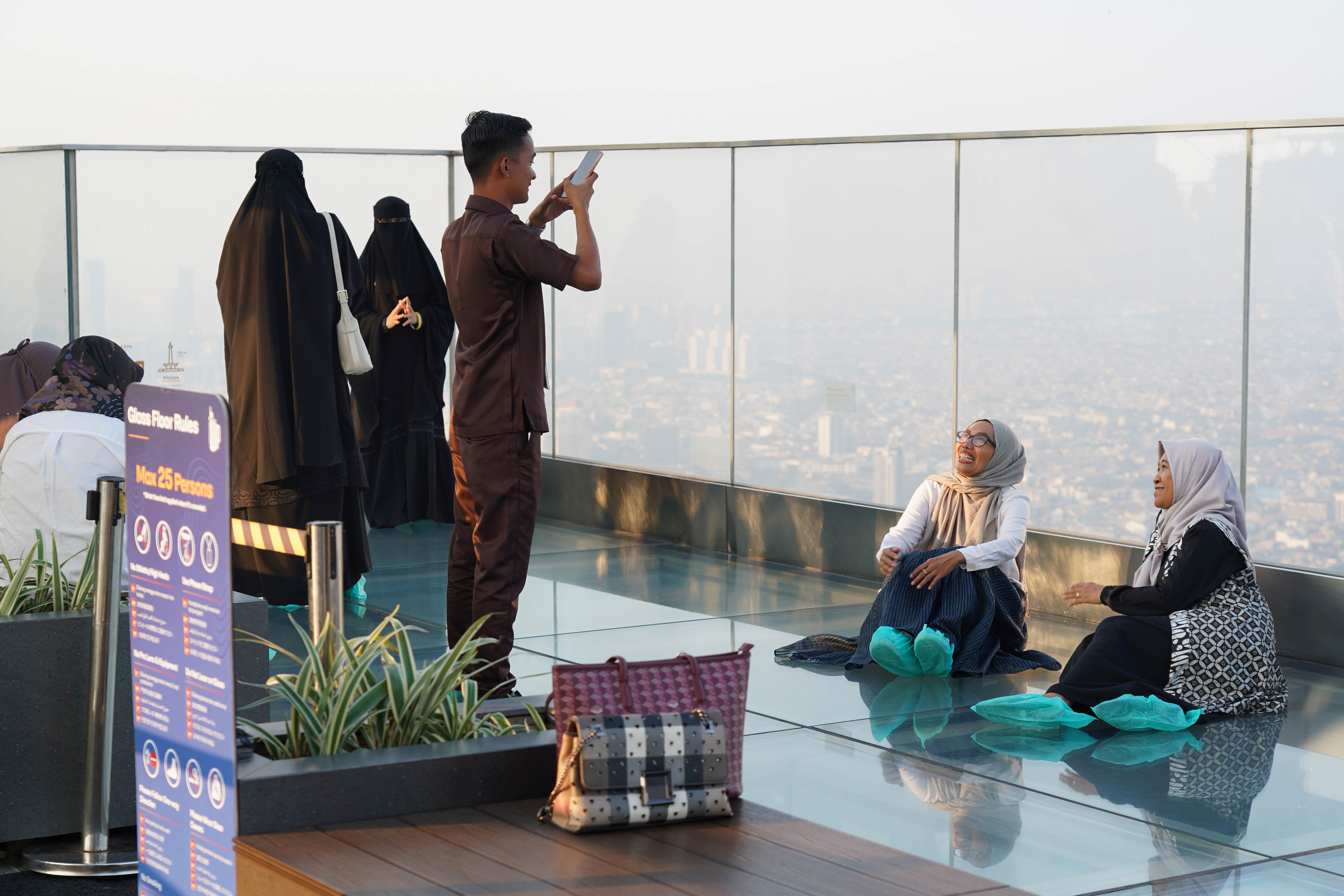 Warga berfoto saat berkunjung ke Sky Garden UP at Thamrin Nine di Autograph Tower, Jakarta Pusat, Rabu (15/7/2026). Objek wisata tersebut menawarkan tempat untuk menikmati suasana panorama Kota Jakarta dari atas gedung tertinggi di Indonesia dengan ketinggian 385 meter.