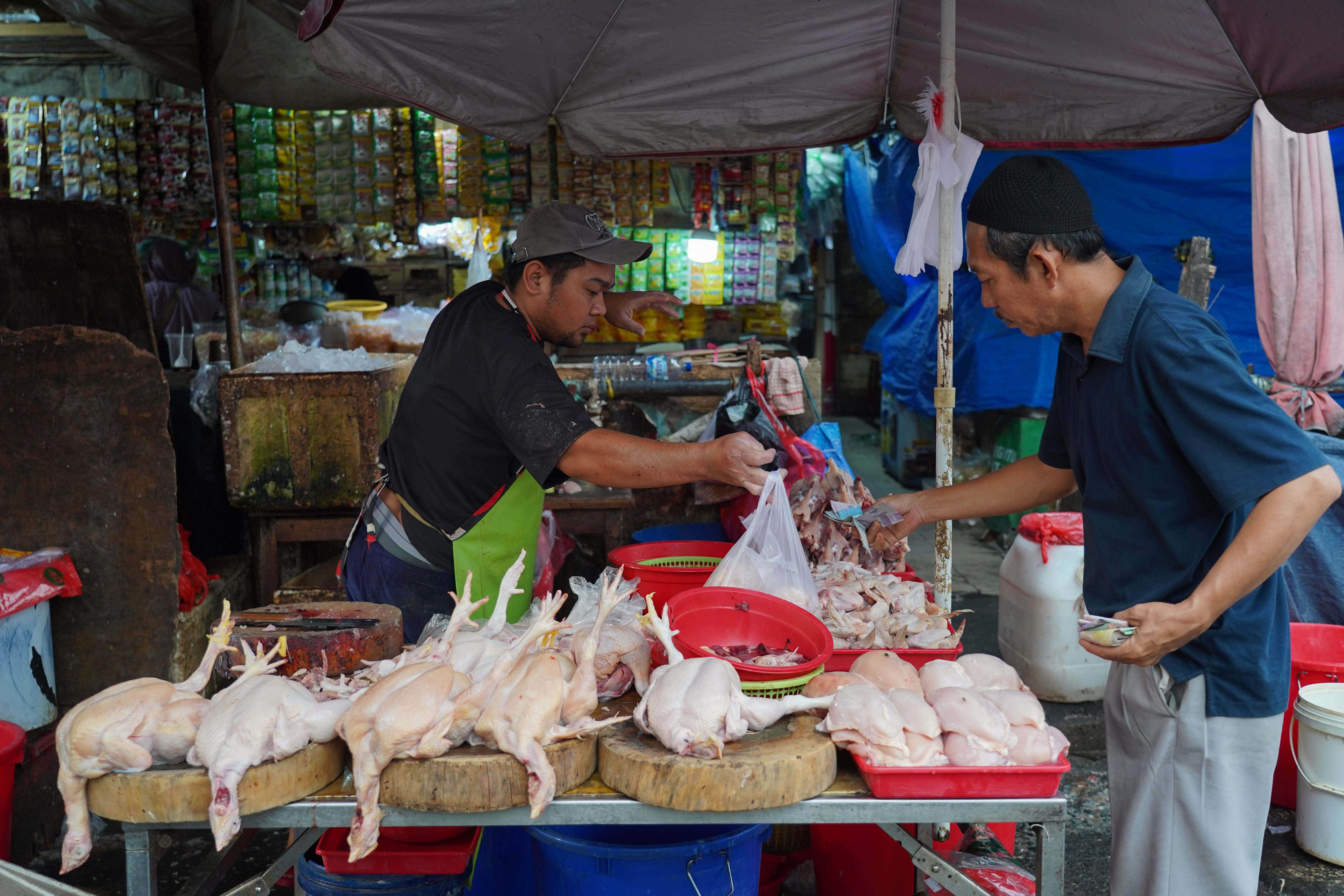 Pedagang melayani warga yang membeli ayam potong di Pasar Kebayoran Lama, Jakarta, Kamis (23/7/2026). Berdasarkan keterangan pedagang, seiring dengan naiknya permintaan dari konsumen harga ayam potong kembali stabil Rp 38 ribu dari sebelumnya Rp 30 ribu per kilogram.