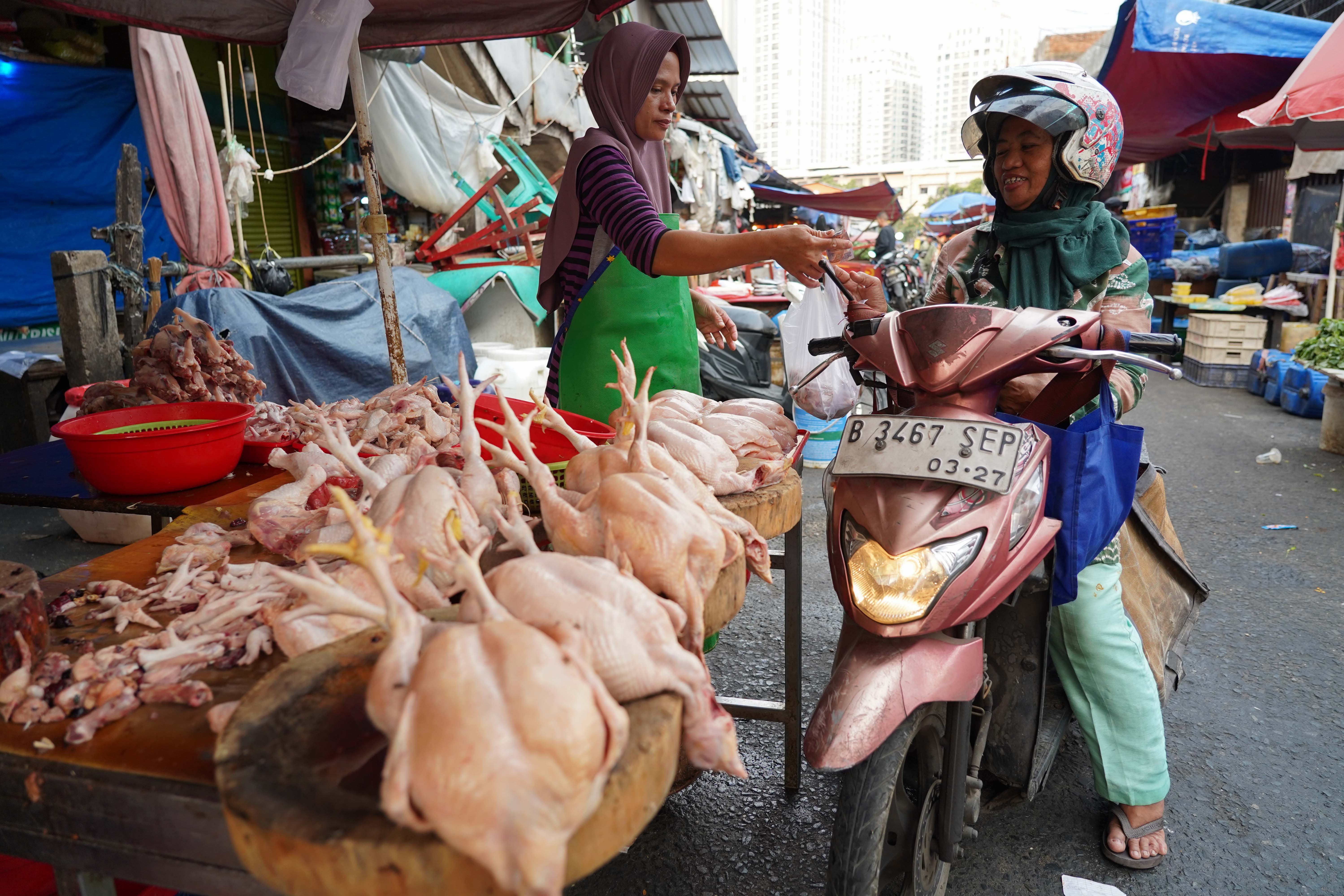 Pedagang melayani warga yang membeli ayam potong di Pasar Kebayoran Lama, Jakarta, Kamis (23/7/2026). Berdasarkan keterangan pedagang, seiring dengan naiknya permintaan dari konsumen harga ayam potong kembali stabil Rp 38 ribu dari sebelumnya Rp 30 ribu per kilogram.