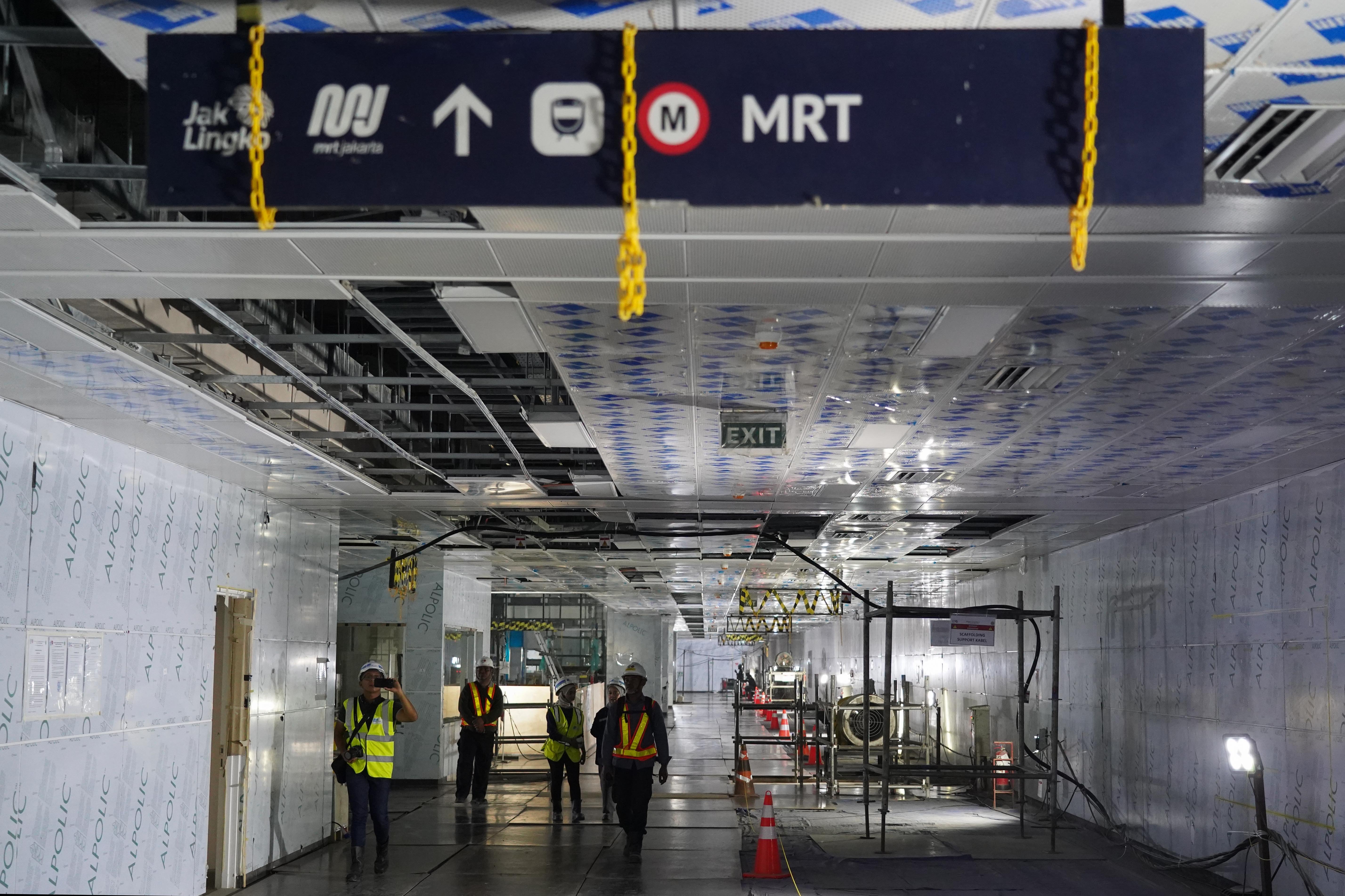 Pekerja berjalan di koridor saat pembangunan Stasiun MRT Monas, Jakarta, Rabu (22/7/2026). Stasiun yang dirancang sebagai stasiun ikonik yang menyatu dengan kawasan cagar budaya Monumen Nasional ini progres konstruksinya telah mencapai sekitar 92% dan ditargetkan beroperasi pada akhir 2027.