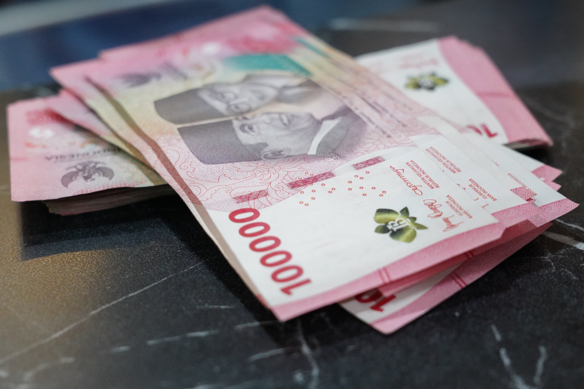 Pecahan mata uang rupiah di gerai penukaran uang asing Dolarasia Money Changer, Melawai, Jakarta Selatan, Senin (27/7/2026). Nilai tukar rupiah terhadap dolar Amerika Serikat (AS) ditutup melemah 46 poin atau 0,26 persen menjadi Rp18.009 dari sebelumnya sebelumnya di level Rp17.963 per dolar AS.