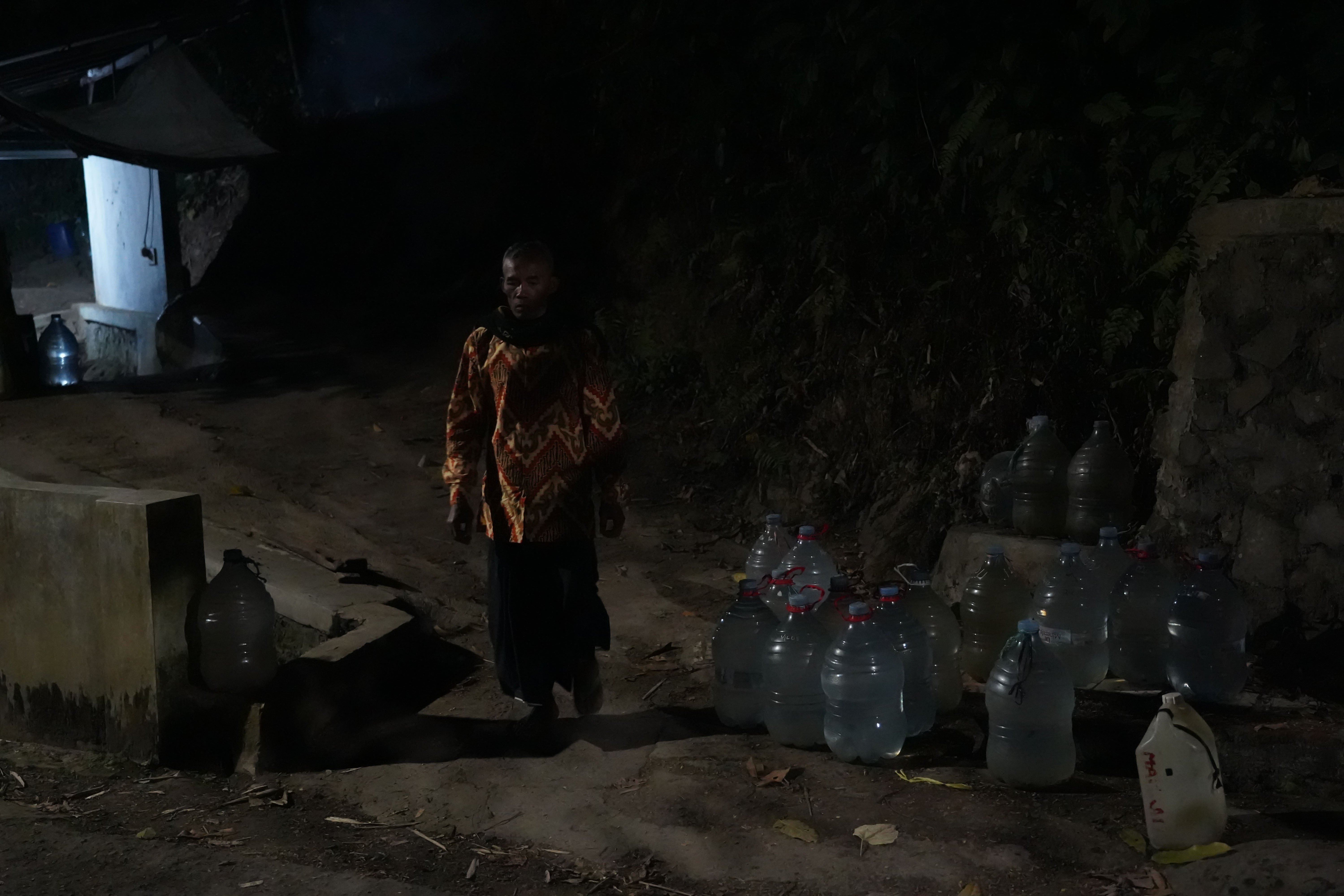 Warga berjalan di dekat galon yang telah terisi air di sumber mata air Sumur Bendung di kawasan Gunung Batur 2, Kelurahan Mekarsari, Kota Cilegon, Banten, Jumat (31/7/2026). Musim kemarau yang melanda wilayah tersebut berdampak pada menyusutnya debit air di sumber mata air sehingga membuat warga harus memasuki kawasan hutan untuk memperoleh air bersih.