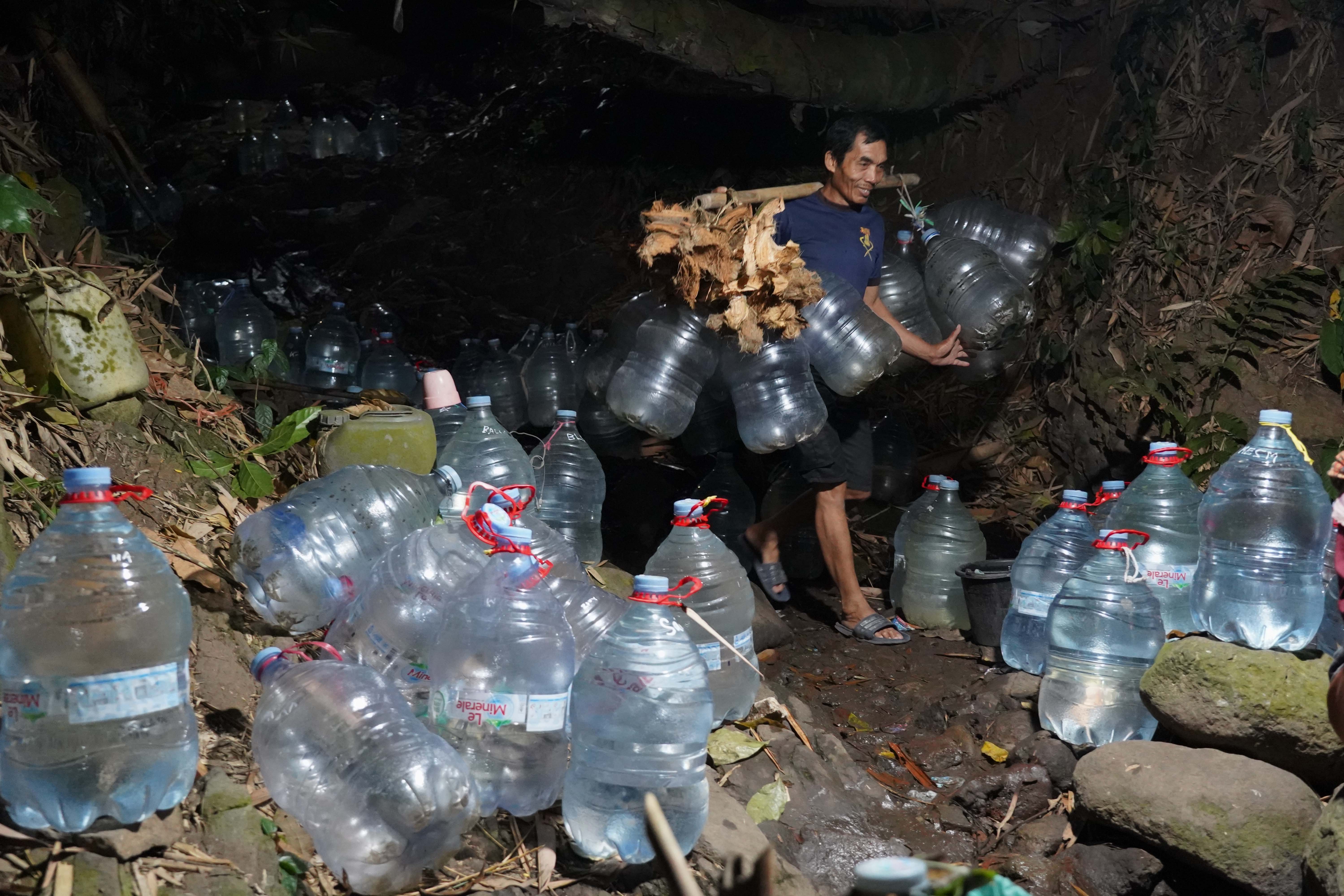 Warga membawa galon yang akan diisi air di sumber mata air Sumur Bendung di kawasan Gunung Batur 2, Kelurahan Mekarsari, Kota Cilegon, Banten, Jumat (31/7/2026). Musim kemarau yang melanda wilayah tersebut berdampak pada menyusutnya debit air di sumber mata air sehingga membuat warga harus memasuki kawasan hutan untuk memperoleh air bersih.