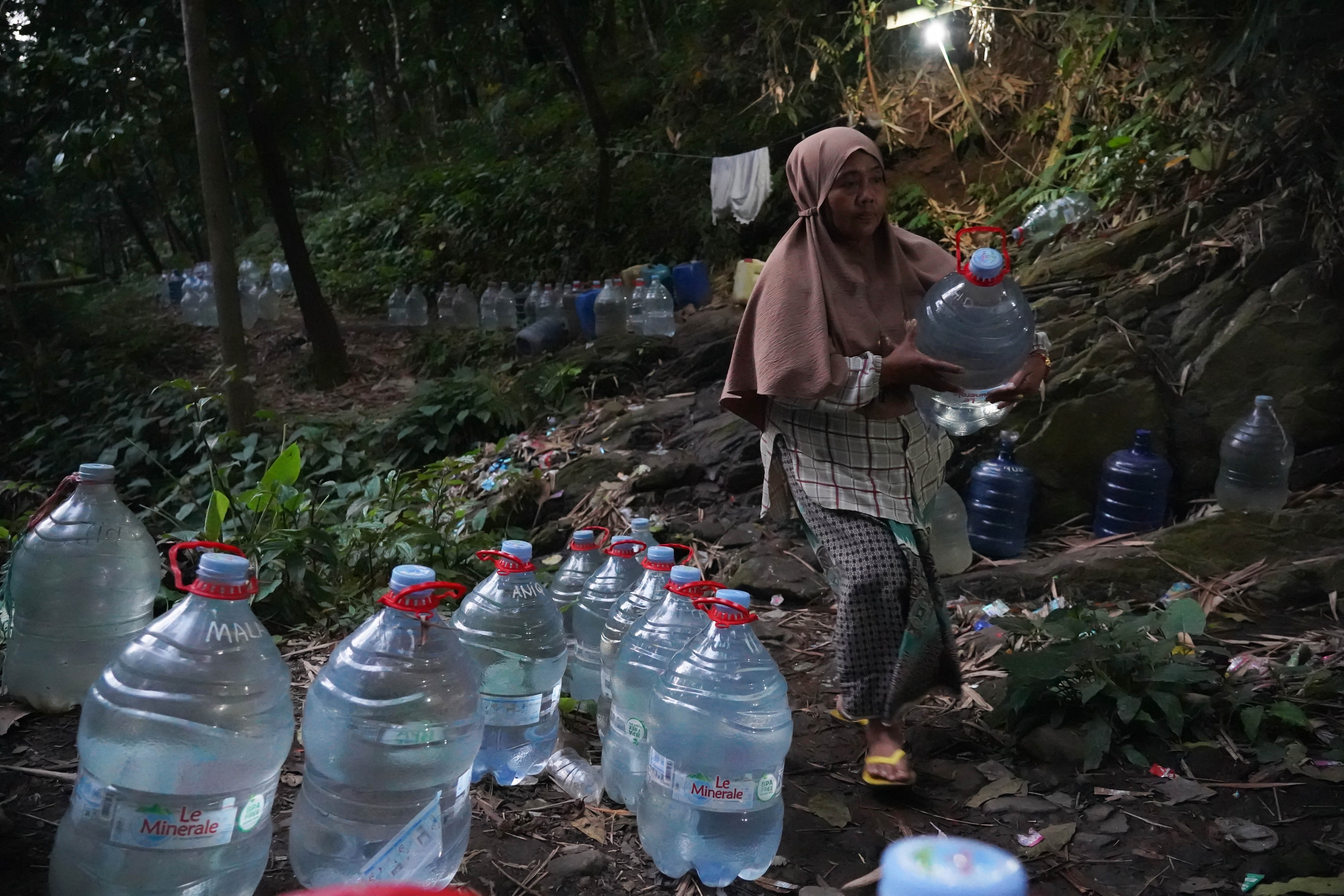 Hadaroh (40) membawa galon yang telah terisi air di sumber mata air Sumur Bendung di kawasan Gunung Batur 2, Kelurahan Mekarsari, Kota Cilegon, Banten, Jumat (31/7/2026). Musim kemarau yang melanda wilayah tersebut berdampak pada menyusutnya debit air di sumber mata air sehingga membuat warga harus memasuki kawasan hutan untuk memperoleh air bersih.