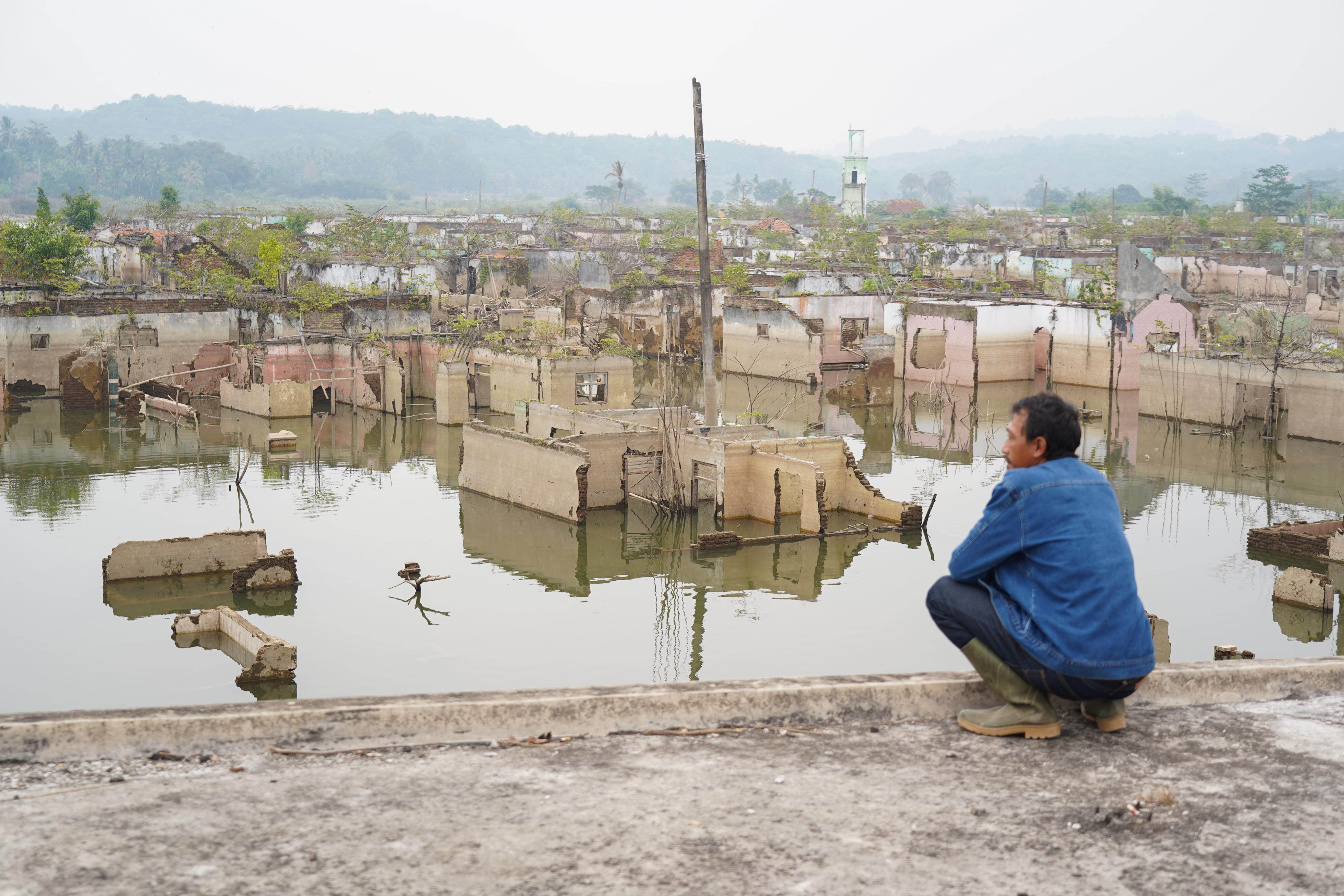 Warga melihat bekas bangunan rumah yang sebelumnya tenggelam air kini muncul saat Waduk Karian mengering di Lebak, Banten, Jumat (31/7/2026). Berdasarkan keterangan warga setempat musim kemarau yang terjadi dalam satu bulan tekakhir membuat debit air di waduk tersebut mulai menyusut.