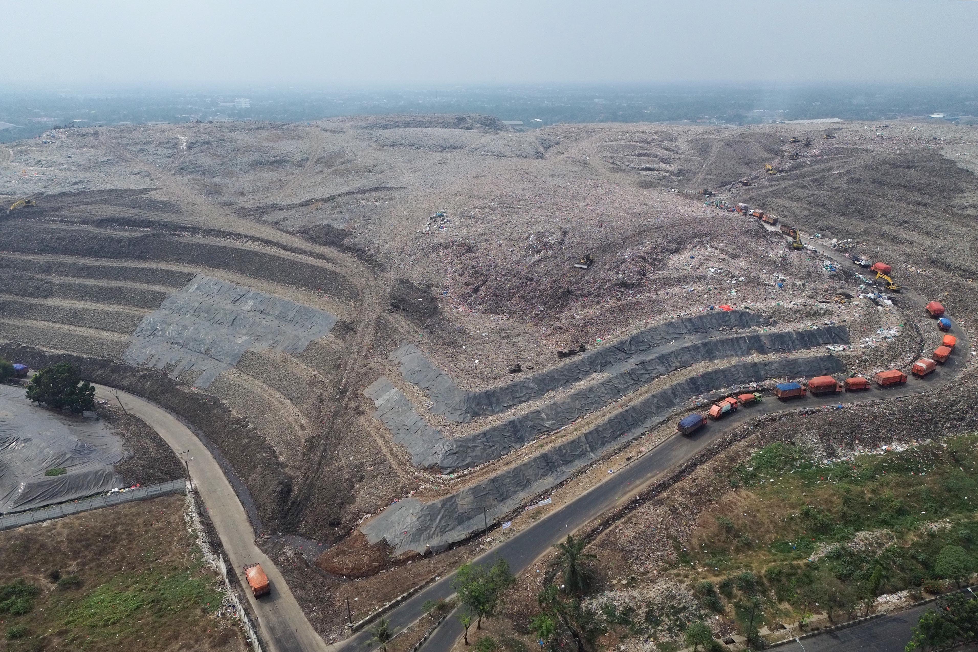 Foto udara sebagian tumpukan sampah yang telah ditutup geomembran di Tempat Pembuangan Sampah Terpadu (TPST) Bantargebang, Kota Bekasi, Jawa Barat, Selasa (4/8/2026). Pemasangan plastik kedap air tersebut merupakan transisi sistem pengolahan sampah dari praktik open dumping menuju controlled landfill yang ditargetkan sepenuhnya diterapkan pada 2029 untuk melindungi area timbunan dan mengurangi cemaran air lindi ke lingkungan.
