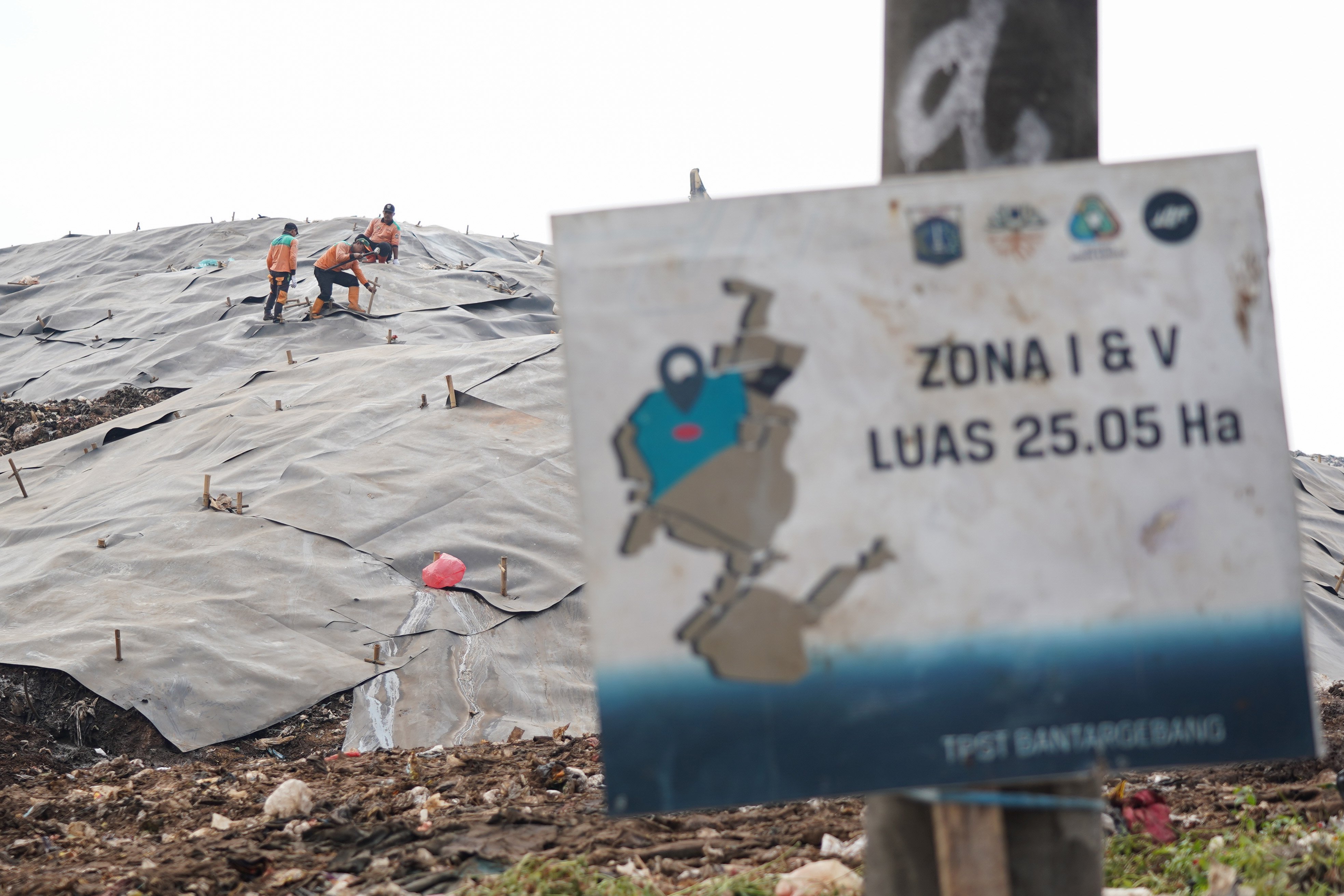 Petugas memasang geomembran untuk menutup tumpukan sampah di Tempat Pengolahan Sampah Terpadu (TPST) Bantargebang, Kota Bekasi, Jawa Barat, Selasa (4/8/2026). Pemasangan plastik kedap air tersebut merupakan transisi sistem pengolahan sampah dari praktik open dumping menuju controlled landfill yang ditargetkan sepenuhnya diterapkan pada 2029 untuk melindungi area timbunan dan mengurangi cemaran air lindi ke lingkungan.