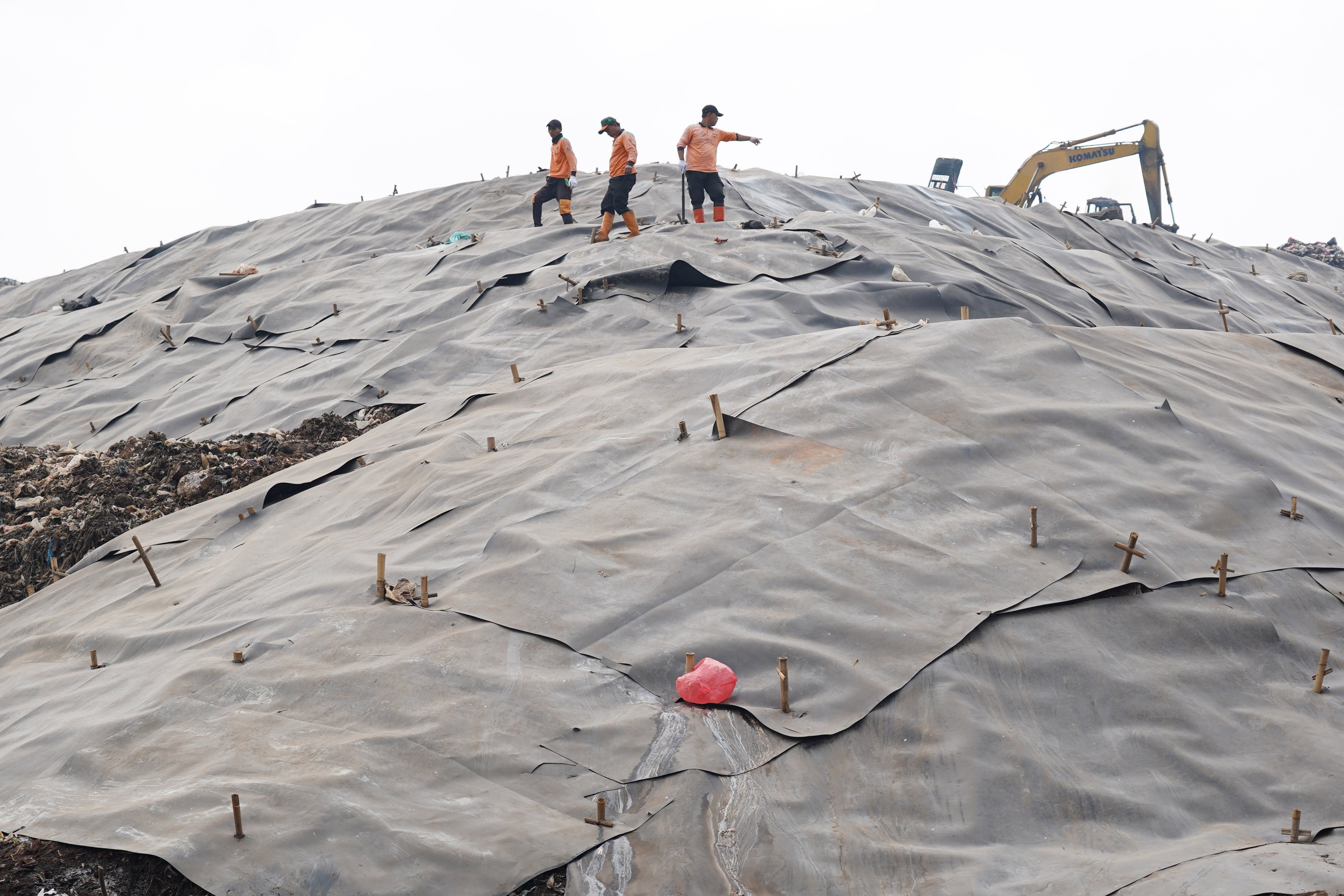 Petugas memasang geomembran untuk menutup tumpukan sampah di Tempat Pengolahan Sampah Terpadu (TPST) Bantargebang, Kota Bekasi, Jawa Barat, Selasa (4/8/2026). Pemasangan plastik kedap air tersebut merupakan transisi sistem pengolahan sampah dari praktik open dumping menuju controlled landfill yang ditargetkan sepenuhnya diterapkan pada 2029 untuk melindungi area timbunan dan mengurangi cemaran air lindi ke lingkungan.