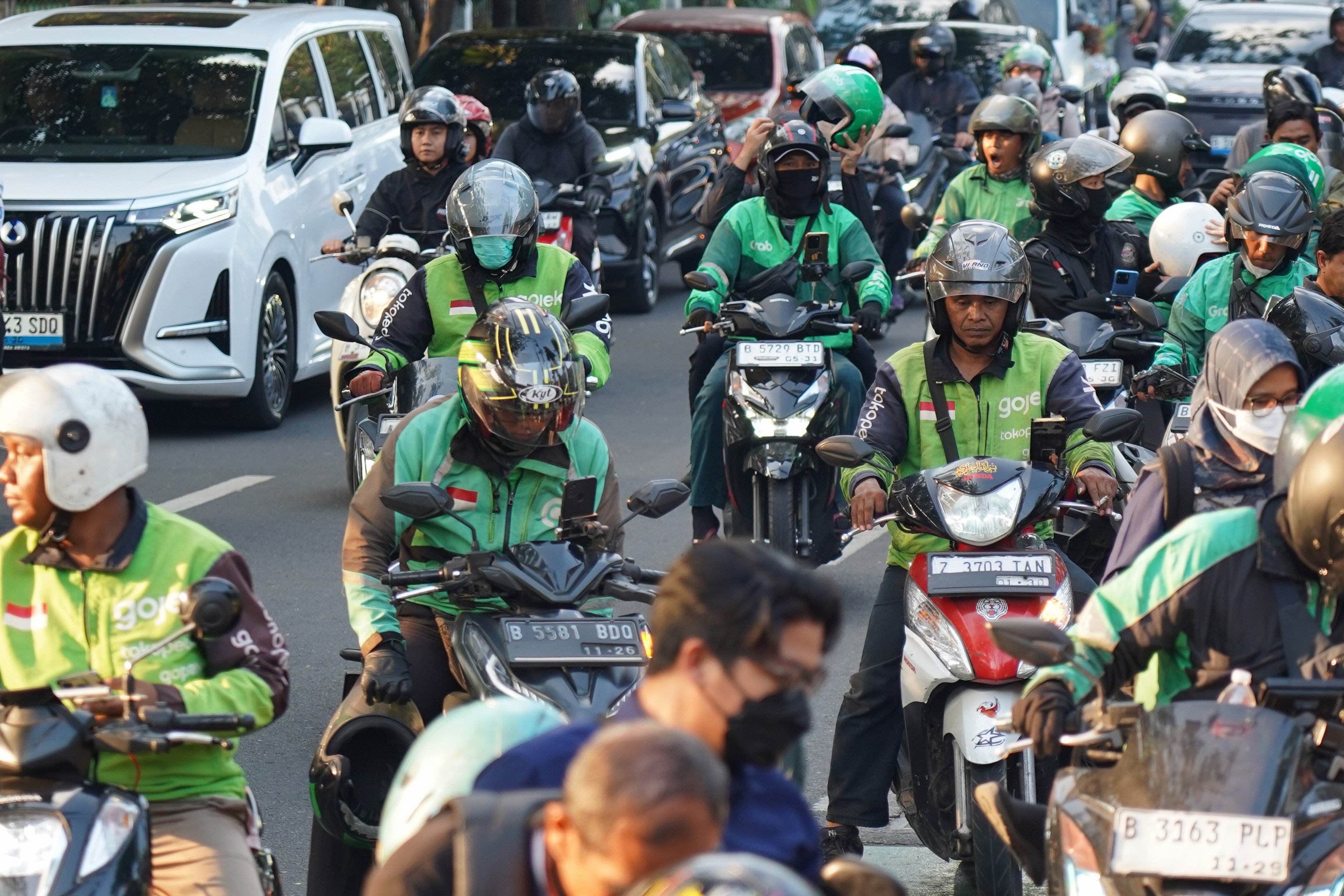 Pengemudi ojek online (ojol) melintas di kawasan Palmerah, Jakarta, Rabu (12/8/2026). Pemerintah menyepakati pengemudi ojol ditetapkan sebagai pelaku usaha mikro, kecil, dan menengah (UMKM) dalam Peraturan Presiden (Perpres) tentang ekosistem transportasi digital atau daring sehingga memperoleh akses Kredit Usaha Rakyat (KUR), pelatihan usaha, insentif perpajakan, serta Bonus Hari Raya (BHR).