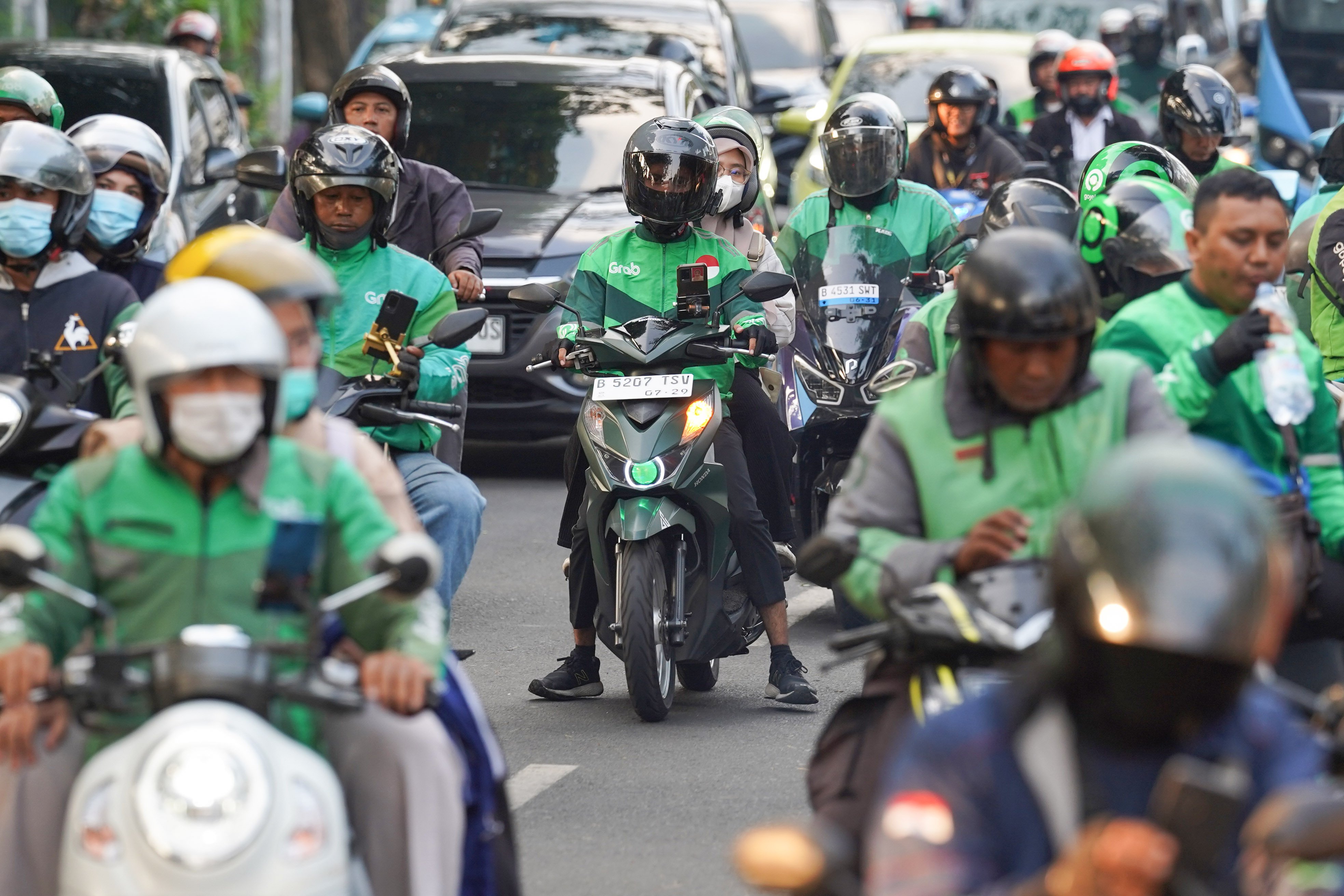 Pengemudi ojek online (ojol) membawa penumpang di kawasan Palmerah, Jakarta, Rabu (12/8/2026). Pemerintah menyepakati pengemudi ojol ditetapkan sebagai pelaku usaha mikro, kecil, dan menengah (UMKM) dalam Peraturan Presiden (Perpres) tentang ekosistem transportasi digital atau daring sehingga memperoleh akses Kredit Usaha Rakyat (KUR), pelatihan usaha, insentif perpajakan, serta Bonus Hari Raya (BHR).