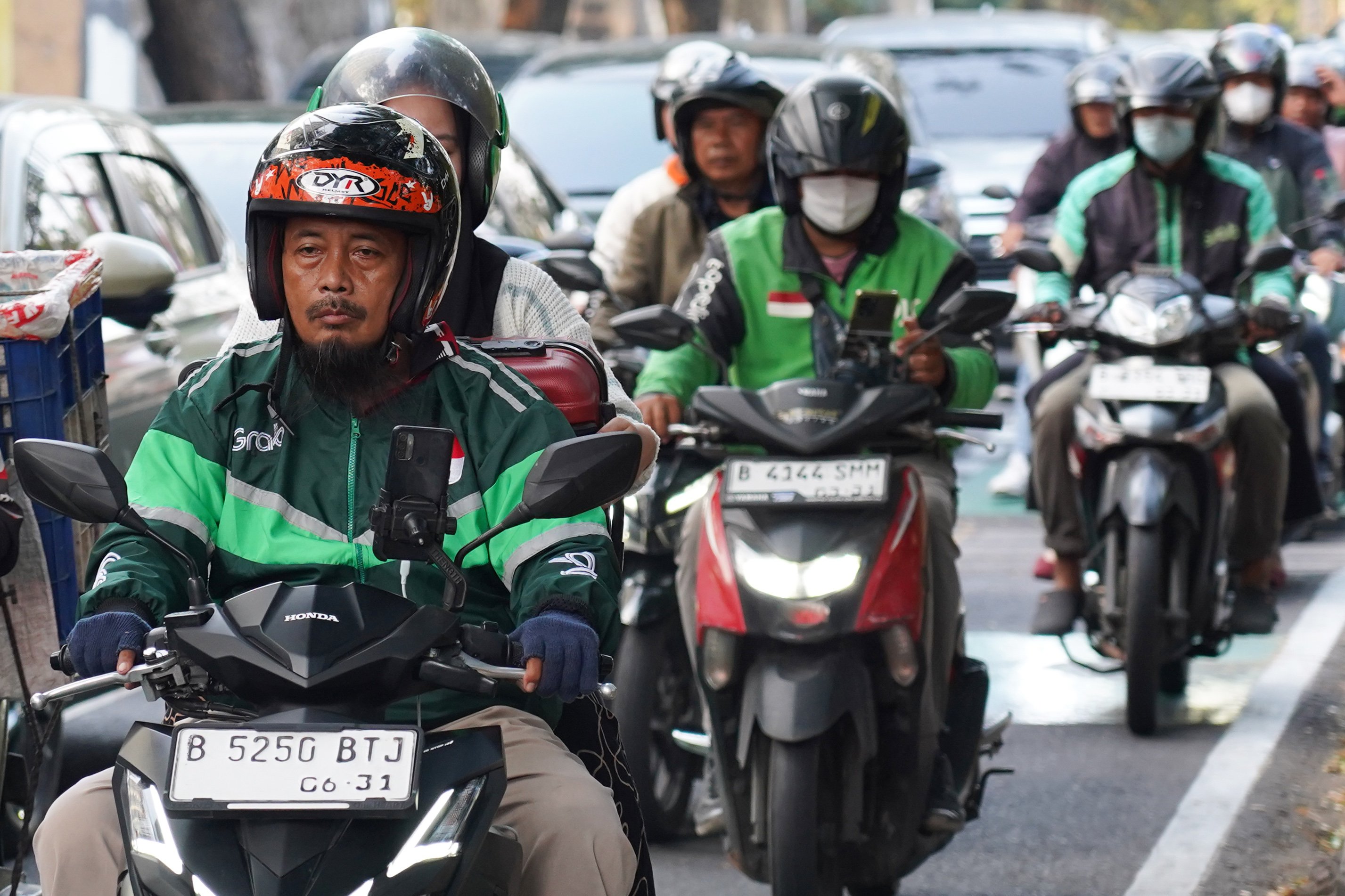 Pengemudi ojek online (ojol) membawa penumpang di kawasan Palmerah, Jakarta, Rabu (12/8/2026). Pemerintah menyepakati pengemudi ojol ditetapkan sebagai pelaku usaha mikro, kecil, dan menengah (UMKM) dalam Peraturan Presiden (Perpres) tentang ekosistem transportasi digital atau daring sehingga memperoleh akses Kredit Usaha Rakyat (KUR), pelatihan usaha, insentif perpajakan, serta Bonus Hari Raya (BHR).