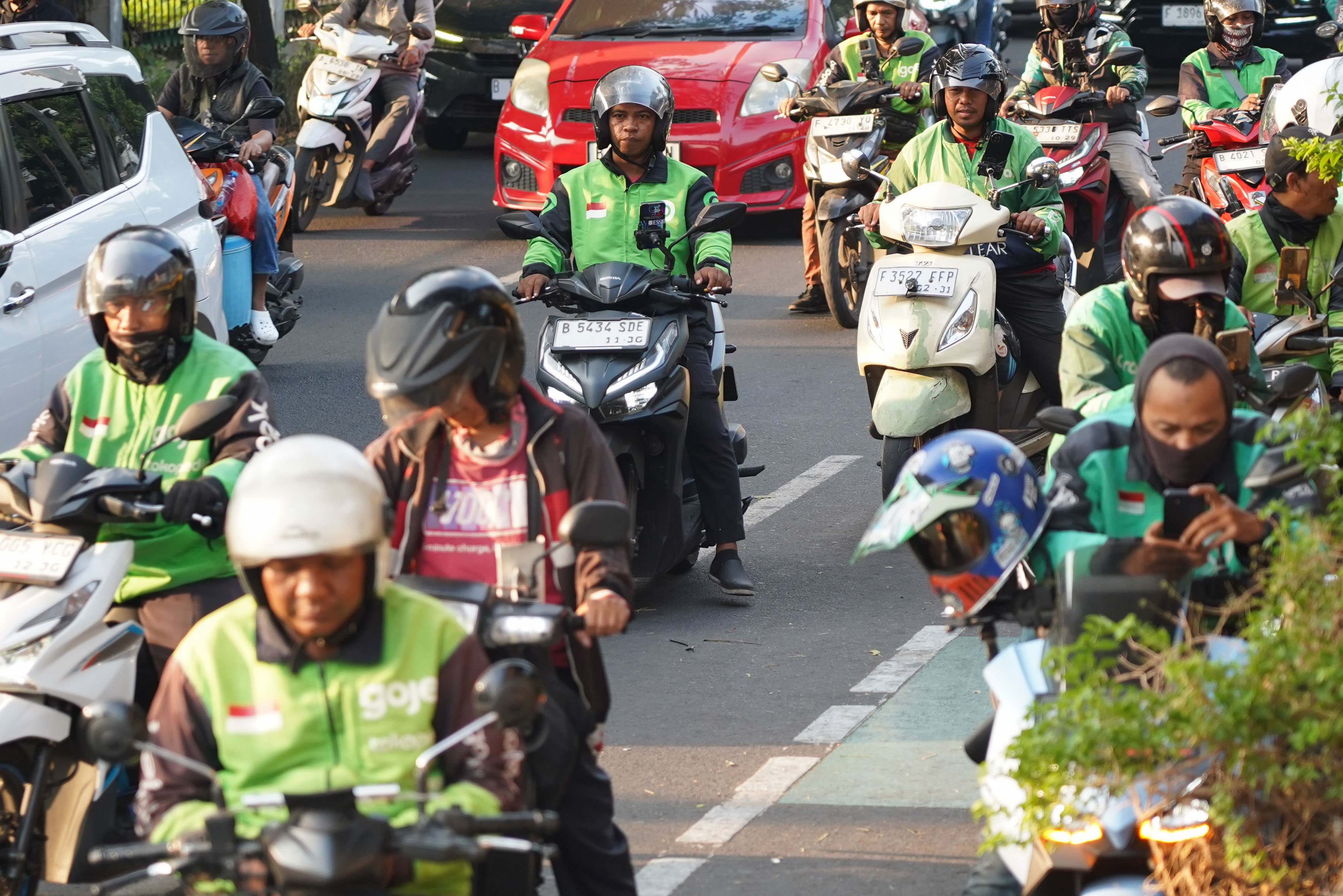 Pengemudi ojek online (ojol) melintas di kawasan Palmerah, Jakarta, Rabu (12/8/2026). Pemerintah menyepakati pengemudi ojol ditetapkan sebagai pelaku usaha mikro, kecil, dan menengah (UMKM) dalam Peraturan Presiden (Perpres) tentang ekosistem transportasi digital atau daring sehingga memperoleh akses Kredit Usaha Rakyat (KUR), pelatihan usaha, insentif perpajakan, serta Bonus Hari Raya (BHR).