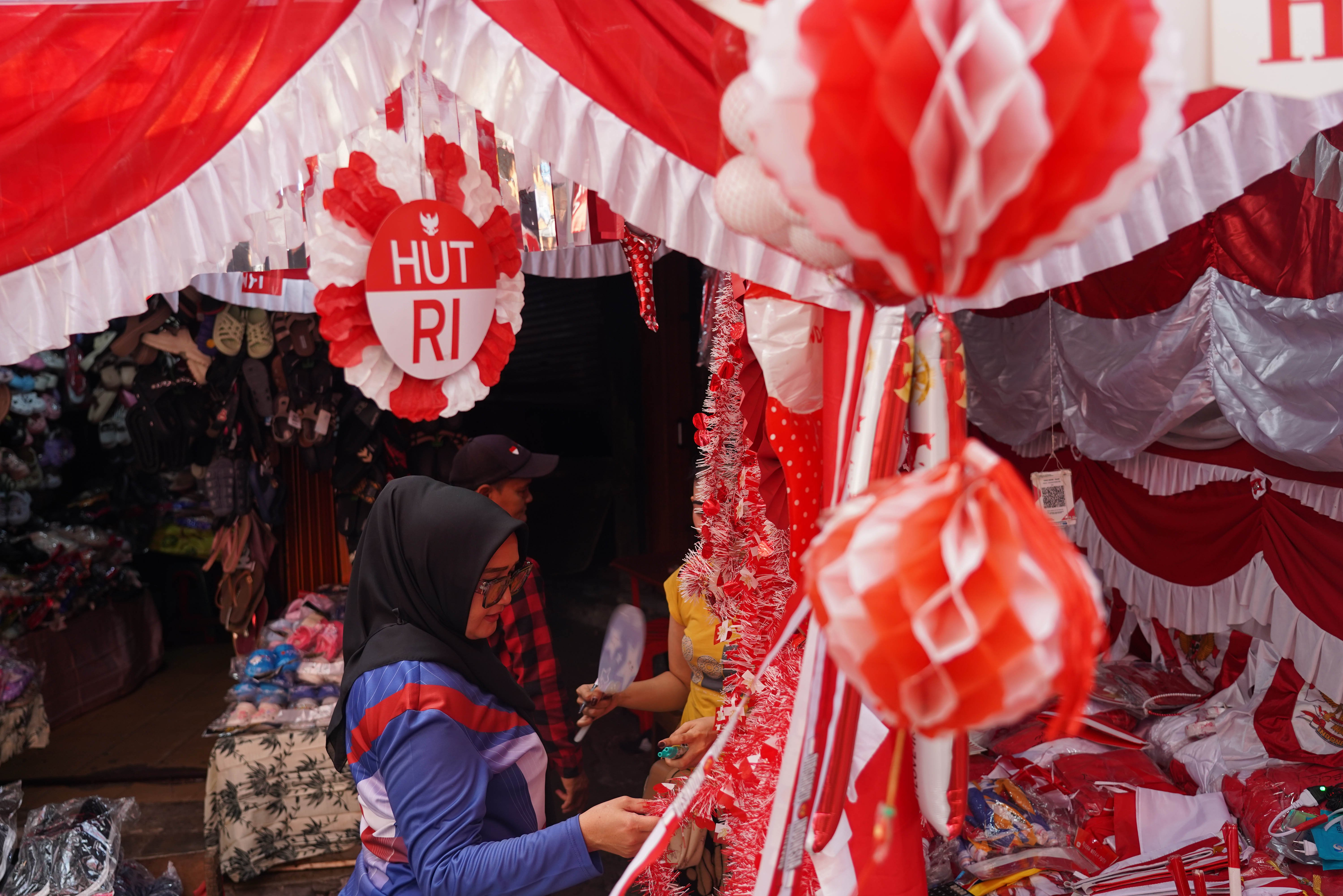 Calon pembeli melihat pernak pernik merah putih yang dijual di Pasar Jatinegara, Jakarta Timur, Rabu (12/8/2026). Berdasarkan keterangan pedagang, menjelang Hari Ulang Tahun (HUT) Kemerdekaan Republik Indonesia ke-81 pada 17 Agustus 2026, penjualan aksesoris bernuansa merah putih meningkat dua kali lipat dibandingkan tahun lalu.