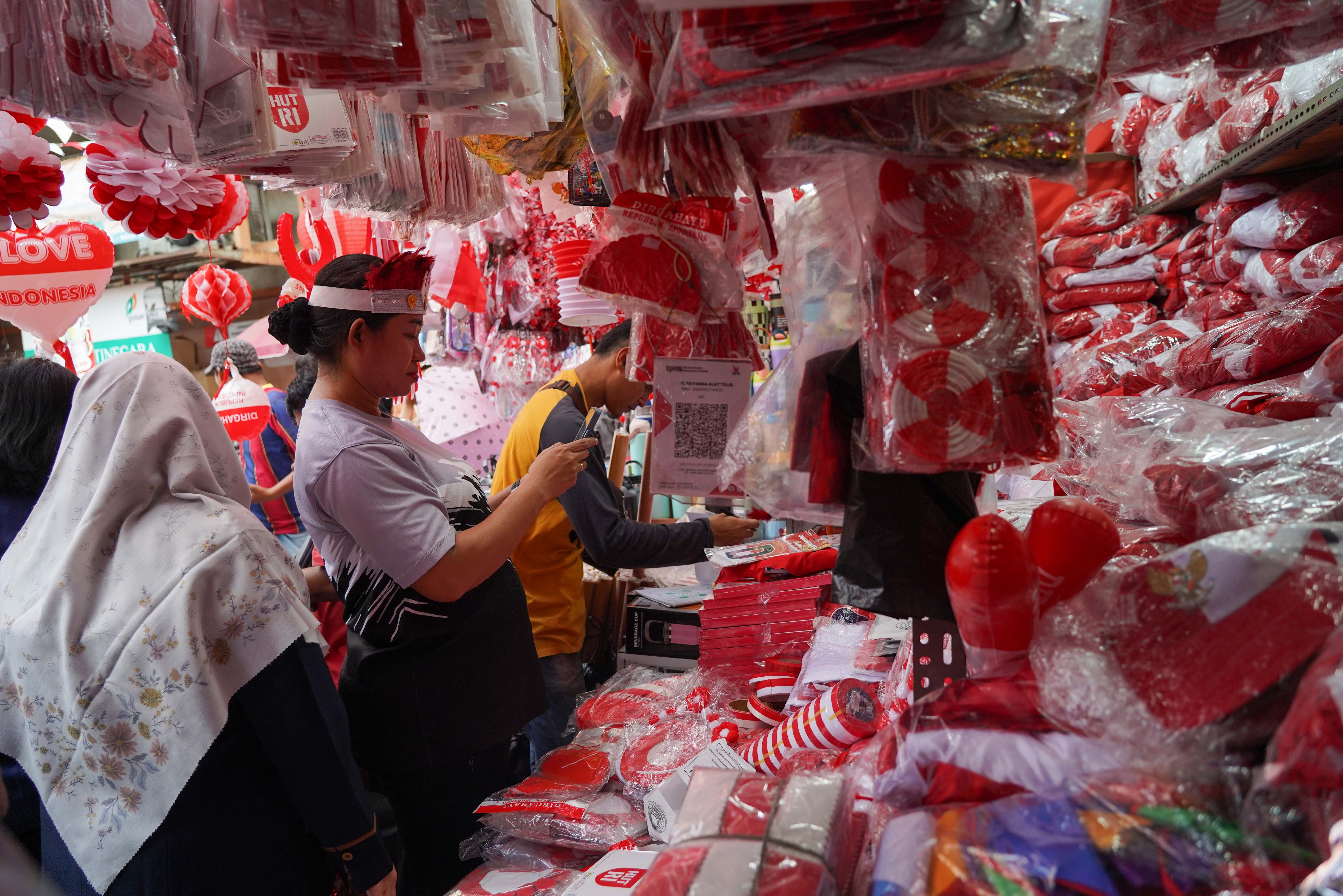 Calon pembeli melihat pernak pernik merah putih yang dijual di Pasar Jatinegara, Jakarta Timur, Rabu (12/8/2026). Berdasarkan keterangan pedagang, menjelang Hari Ulang Tahun (HUT) Kemerdekaan Republik Indonesia ke-81 pada 17 Agustus 2026, penjualan aksesoris bernuansa merah putih meningkat dua kali lipat dibandingkan tahun lalu.