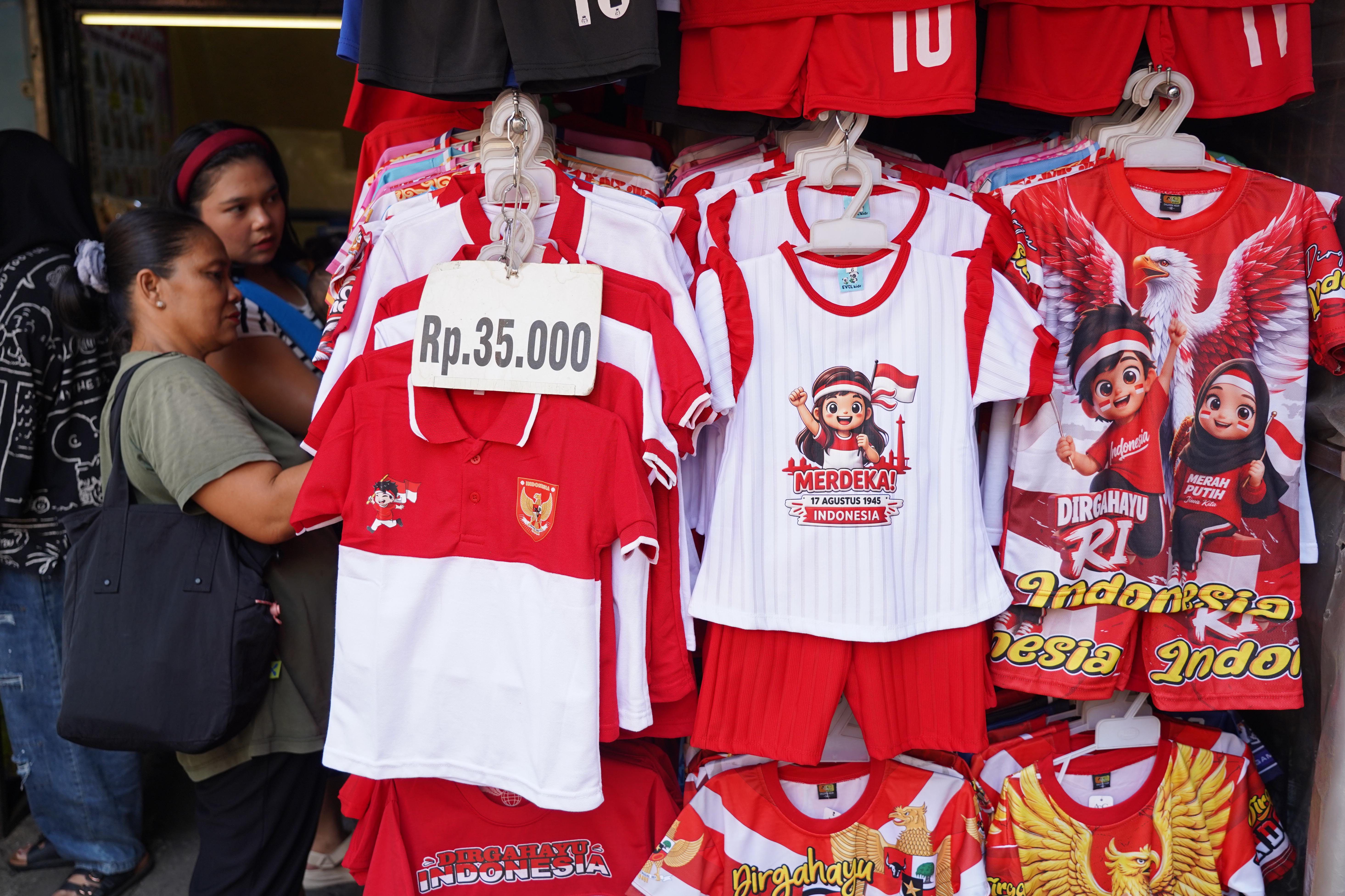 Calon pembeli melihat kaos bertema merah putih yang dijual di Pasar Jatinegara, Jakarta Timur, Rabu (12/8/2026). Berdasarkan keterangan pedagang, menjelang Hari Ulang Tahun (HUT) Kemerdekaan Republik Indonesia ke-81 pada 17 Agustus 2026, penjualan aksesoris bernuansa merah putih meningkat dua kali lipat dibandingkan tahun lalu.