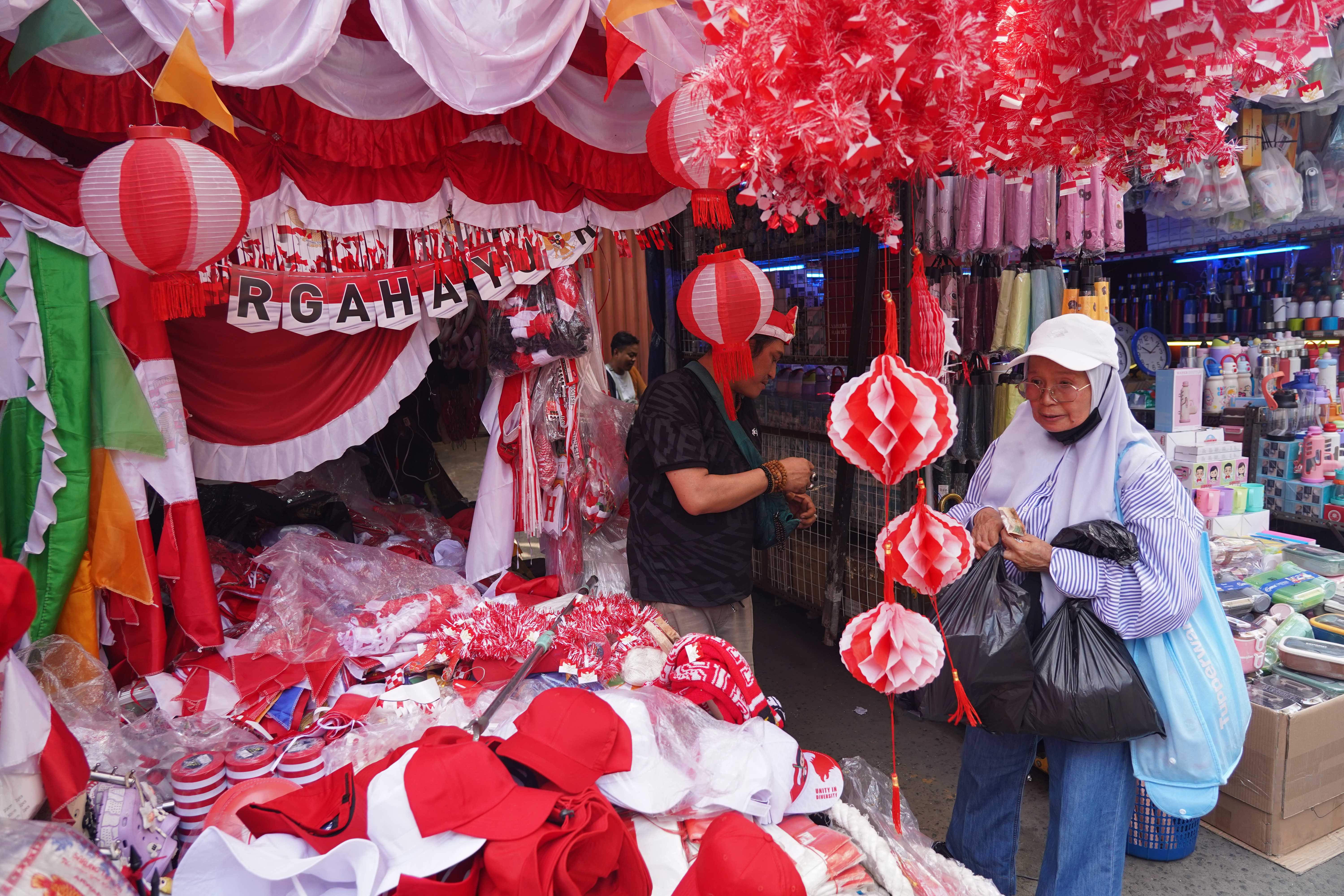 Calon pembeli melihat pernak pernik merah putih yang dijual di Pasar Jatinegara, Jakarta Timur, Rabu (12/8/2026). Berdasarkan keterangan pedagang, menjelang Hari Ulang Tahun (HUT) Kemerdekaan Republik Indonesia ke-81 pada 17 Agustus 2026, penjualan aksesoris bernuansa merah putih meningkat dua kali lipat dibandingkan tahun lalu.
