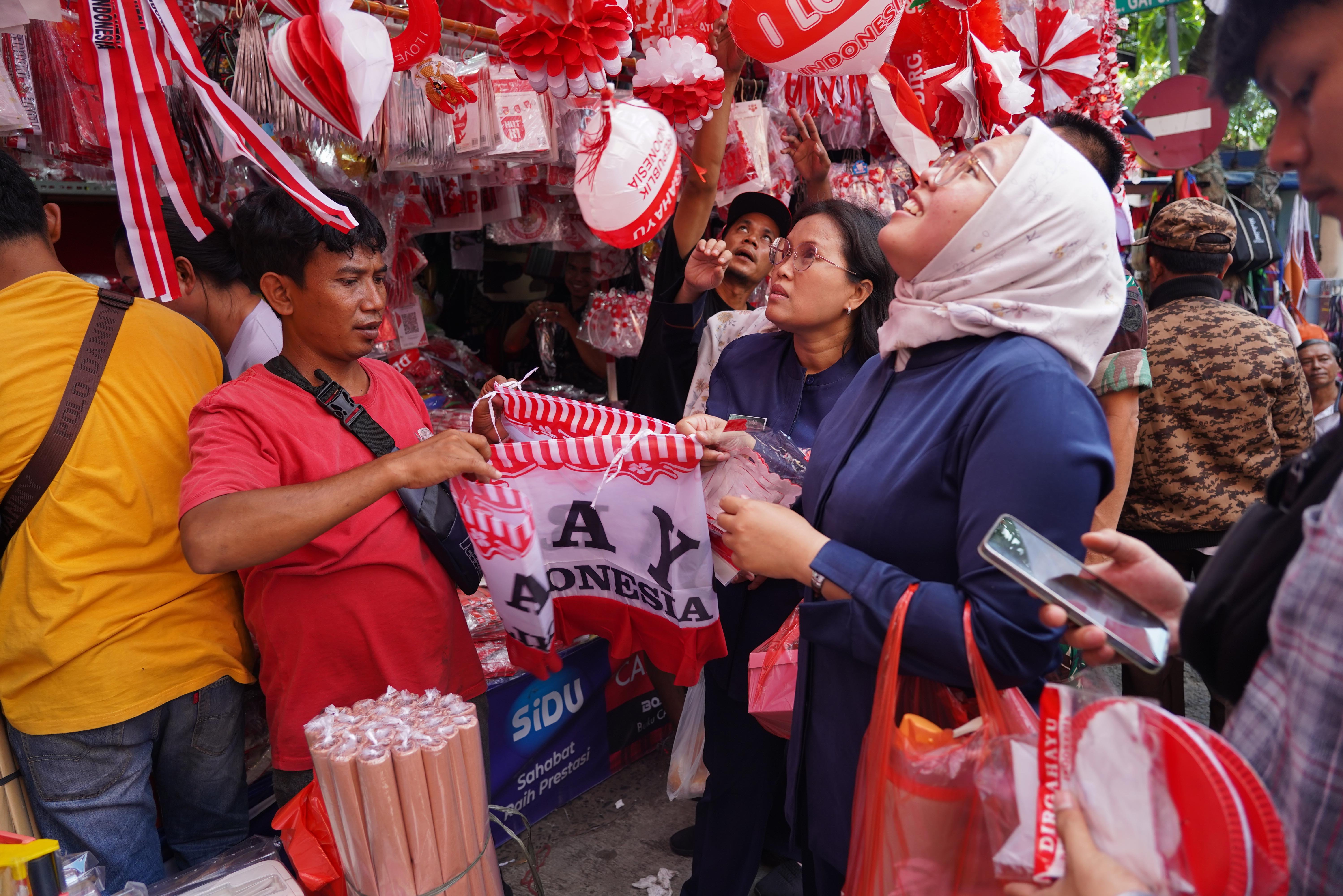 Pedagang melayani calon pembeli yang hendak membeli pernak pernik merah putih di Pasar Jatinegara, Jakarta Timur, Rabu (12/8/2026). Berdasarkan keterangan pedagang, menjelang Hari Ulang Tahun (HUT) Kemerdekaan Republik Indonesia ke-81 pada 17 Agustus 2026, penjualan aksesoris bernuansa merah putih meningkat dua kali lipat dibandingkan tahun lalu.
