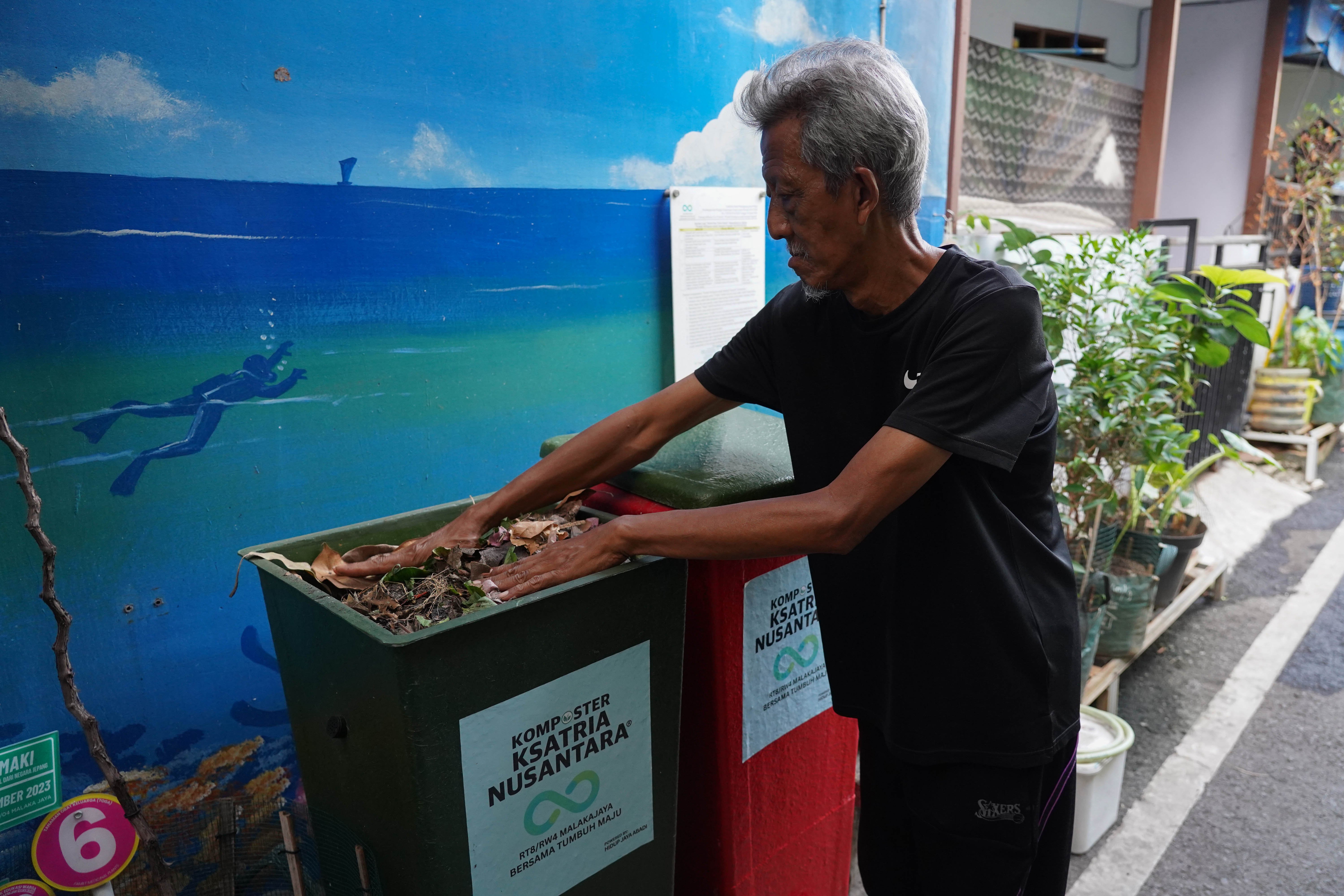 Warga mengumpulkan daun kering untuk diolah menjadi pupuk kompos di kawasan RT.08/RW.04, Malaka Jaya, Duren Sawit, Jakarta Timur.