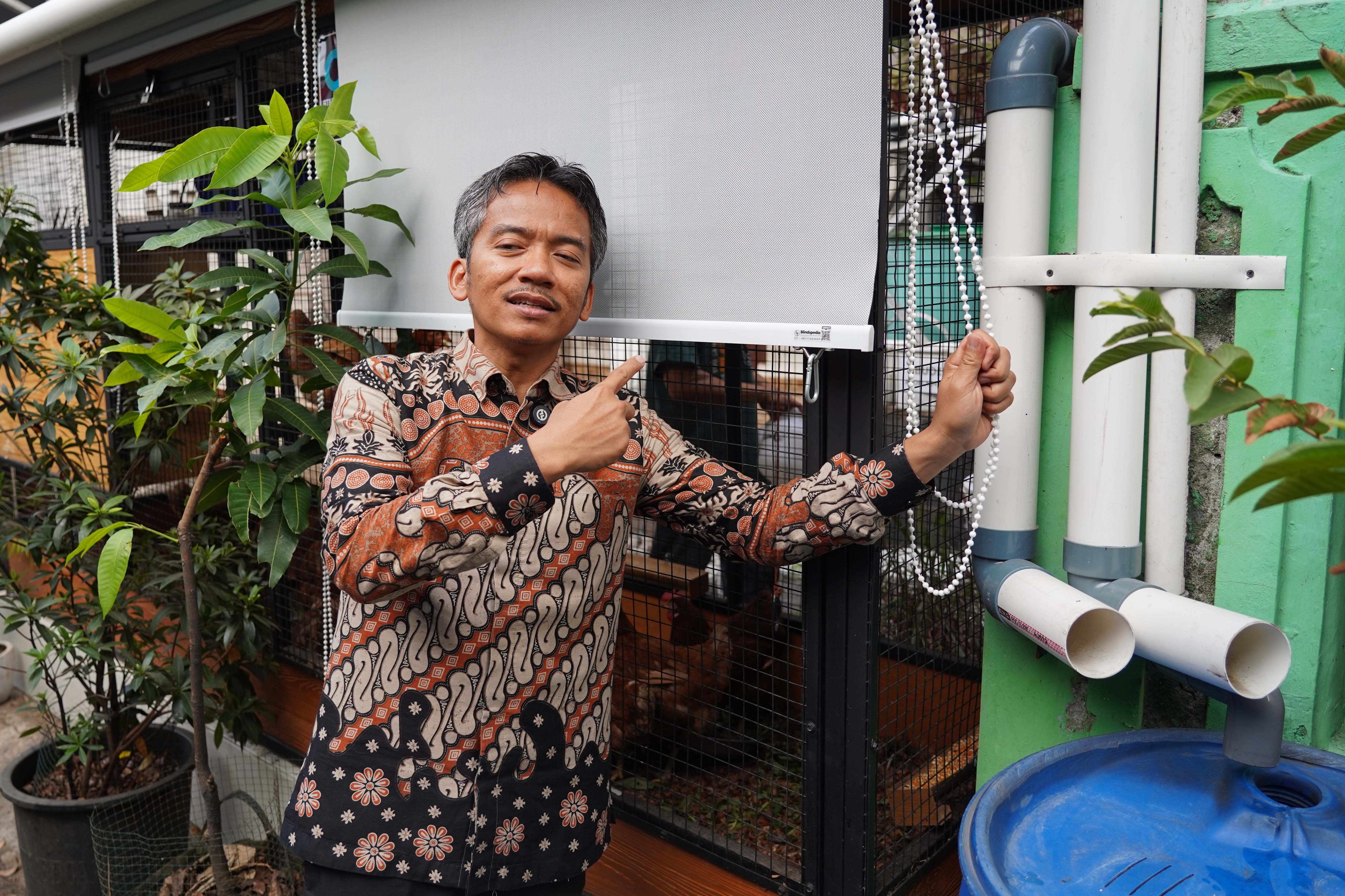 Ketua RT.08/RW.04 Malaka Jaya, Taufiq Supriadi menunjukkan tirai penghalau air hujan untuk menutupi kandang ayam petelur yang diternak di kawasan RT.08/RW.04, Malaka Jaya, Duren Sawit, Jakarta Timur. 