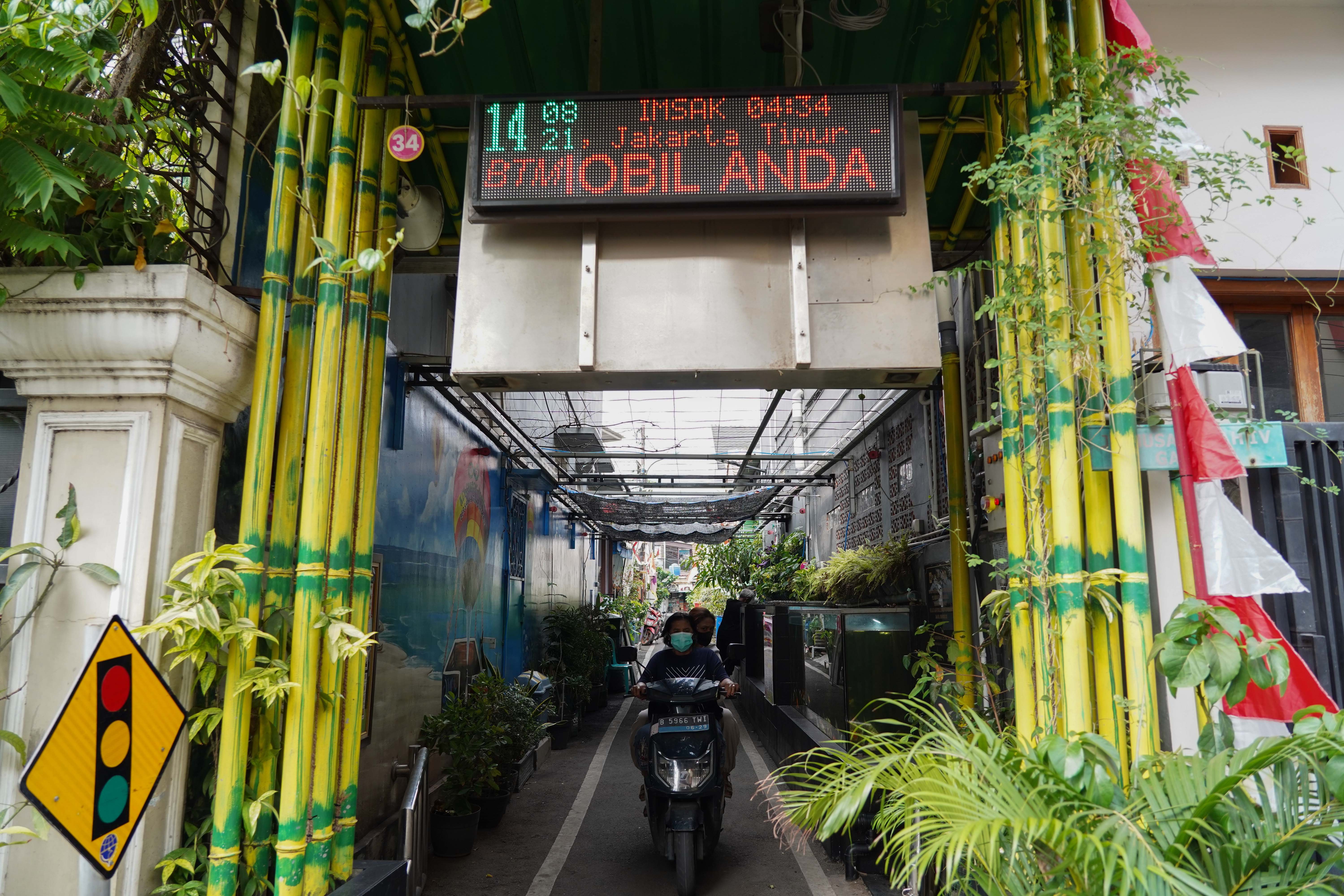 Warga melintas di kawasan Jalan Nusa Indah IV Gang 8, RT.08/RW.04, Malaka Jaya, Duren Sawit, Jakarta Timur.