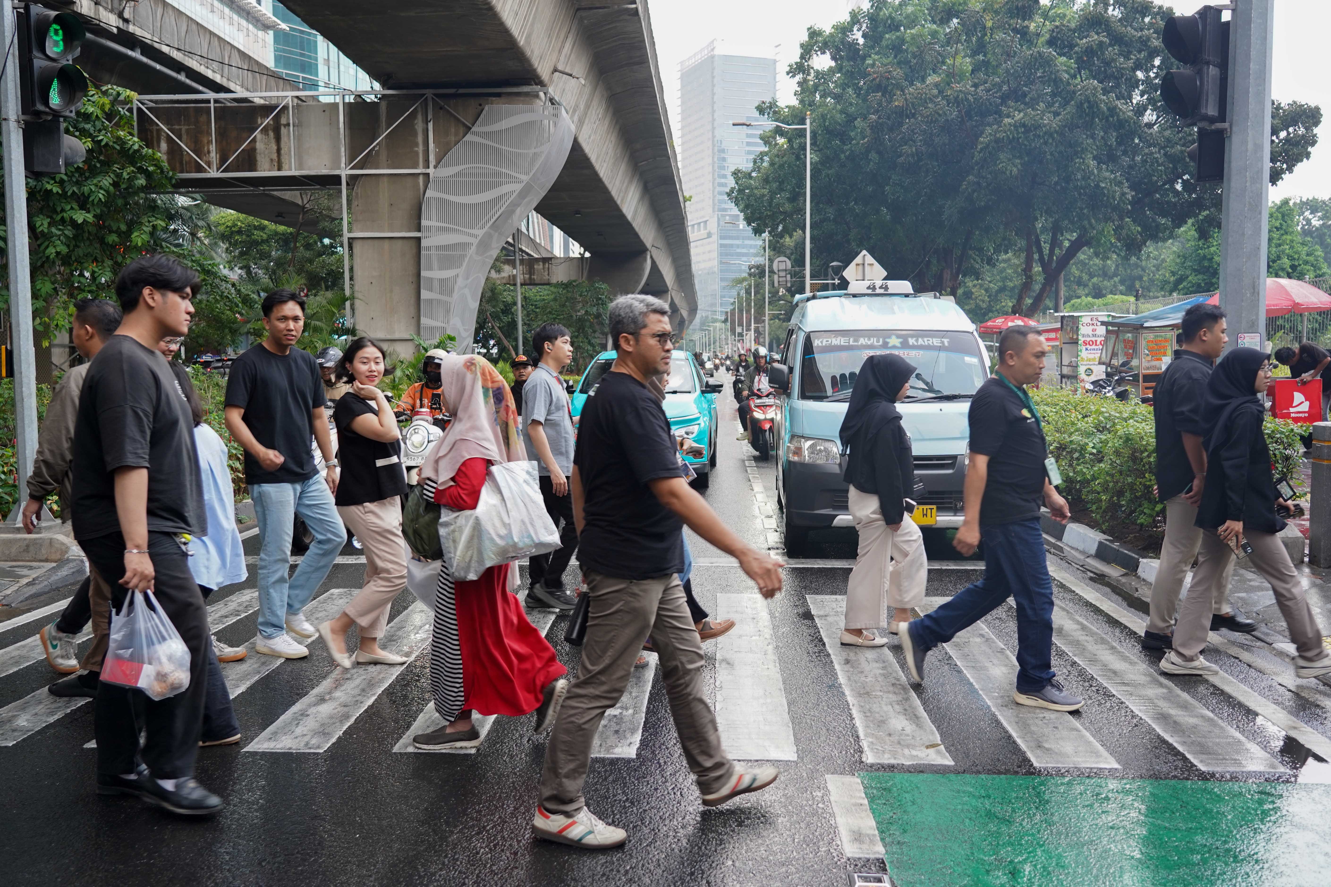 Pekerja beraktivitas di kawasan Kuningan, Jakarta, Rabu (19/8/2026). Pemerintah tengah mengkaji skema pengetatan penyaluran BBM bersubsidi jenis Pertalite dengan mekanisme berdasarkan kendaraan atau kelompok desil (kesejahteraan ekonomi) yakni bagi masyarakat kaya atau status desil 9 dan 10. 