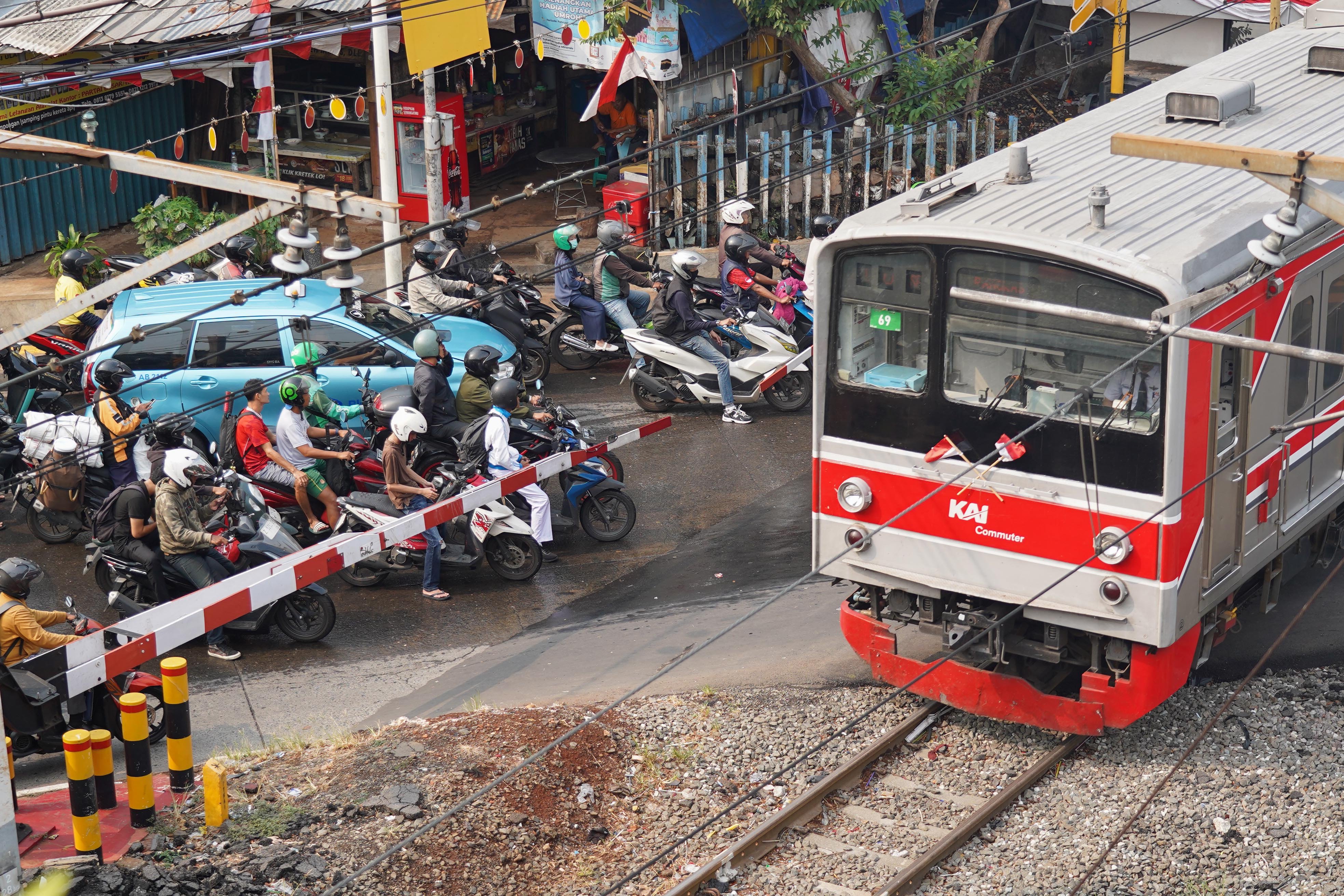 Pengendara menunggu kereta melintas di kawasan Pejompongan, Jakarta, Rabu (19/8/2026). Pemerintah tengah mengkaji skema pengetatan penyaluran bahan bakar minyak (BBM) bersubsidi jenis Pertalite dengan mekanisme berdasarkan kendaraan atau kelompok desil (kesejahteraan ekonomi) yakni bagi masyarakat kaya atau status desil 9 dan 10. 