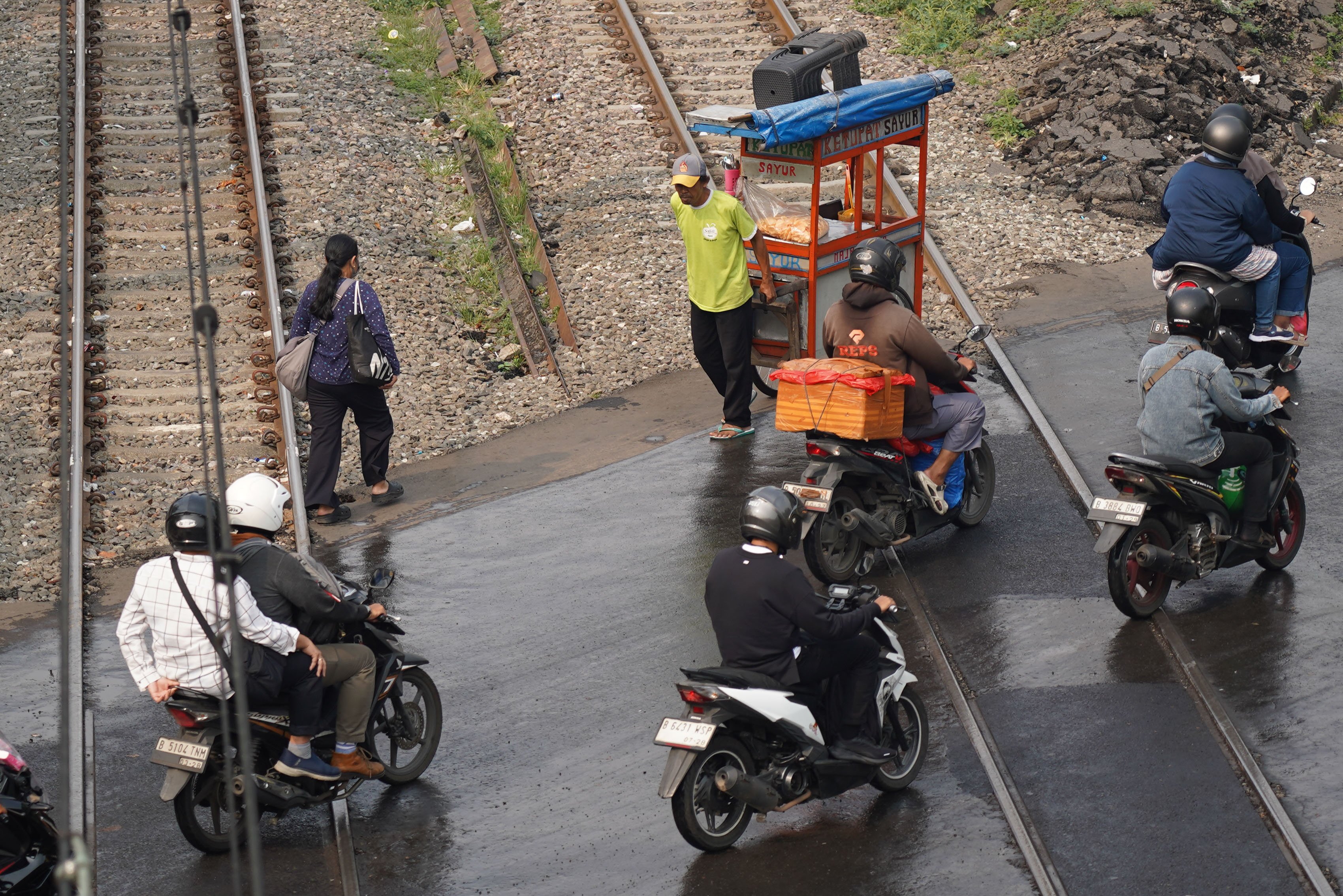 Warga dan pengendara sepeda motor melintas di perlintasan kereta kawasan Pejompongan, Jakarta, Rabu (19/8/2026). Pemerintah tengah mengkaji skema pengetatan penyaluran bahan bakar minyak (BBM) bersubsidi jenis Pertalite dengan mekanisme berdasarkan kendaraan atau kelompok desil (kesejahteraan ekonomi) yakni bagi masyarakat kaya atau status desil 9 dan 10. 