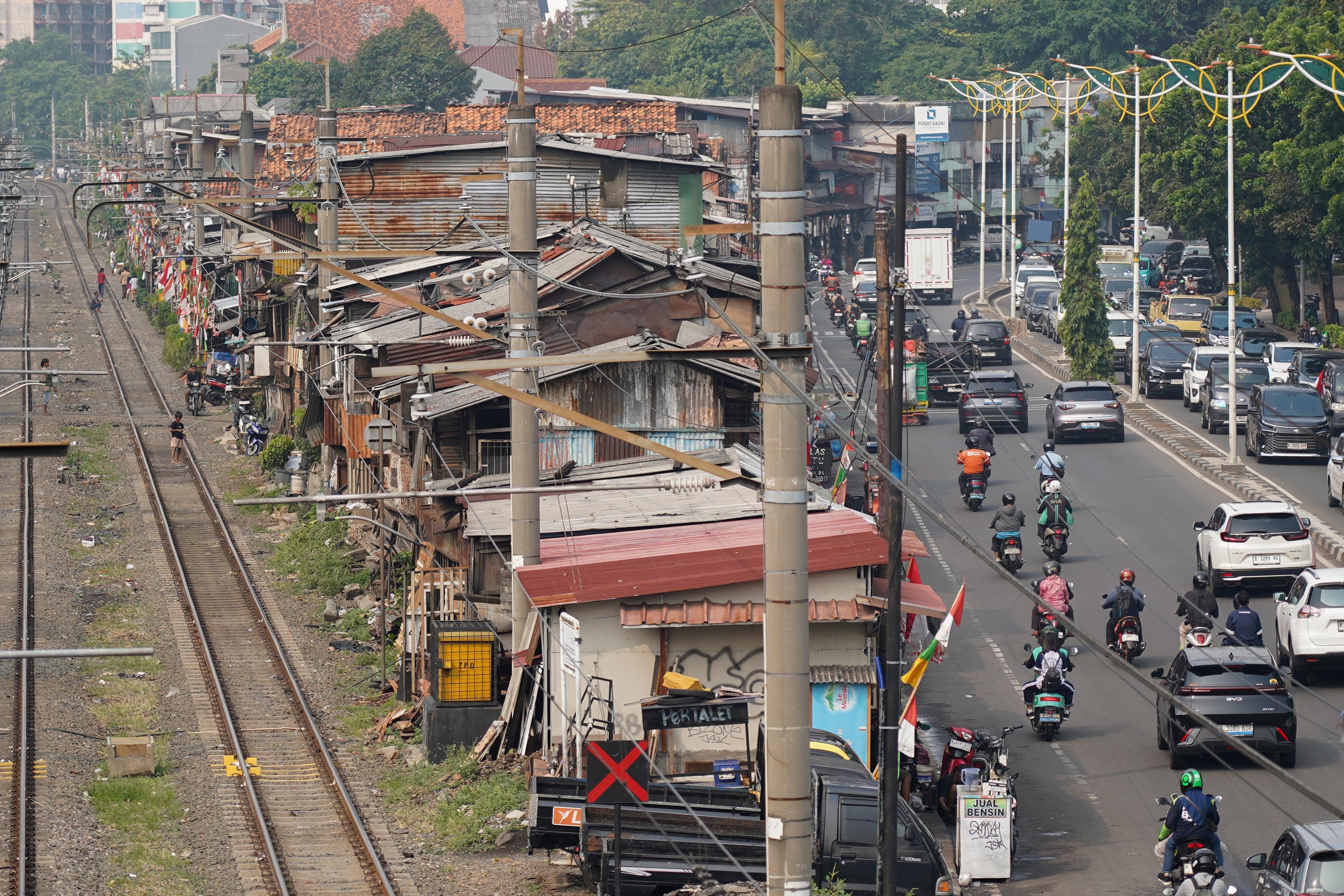 Warga beraktivitas di pemukiman padat bantaran rel kereta kawasan Pejompongan, Jakarta, Rabu (19/8/2026). Pemerintah tengah mengkaji skema pengetatan penyaluran bahan bakar minyak (BBM) bersubsidi jenis Pertalite dengan mekanisme berdasarkan kendaraan atau kelompok desil (kesejahteraan ekonomi) yakni bagi masyarakat kaya atau status desil 9 dan 10. 