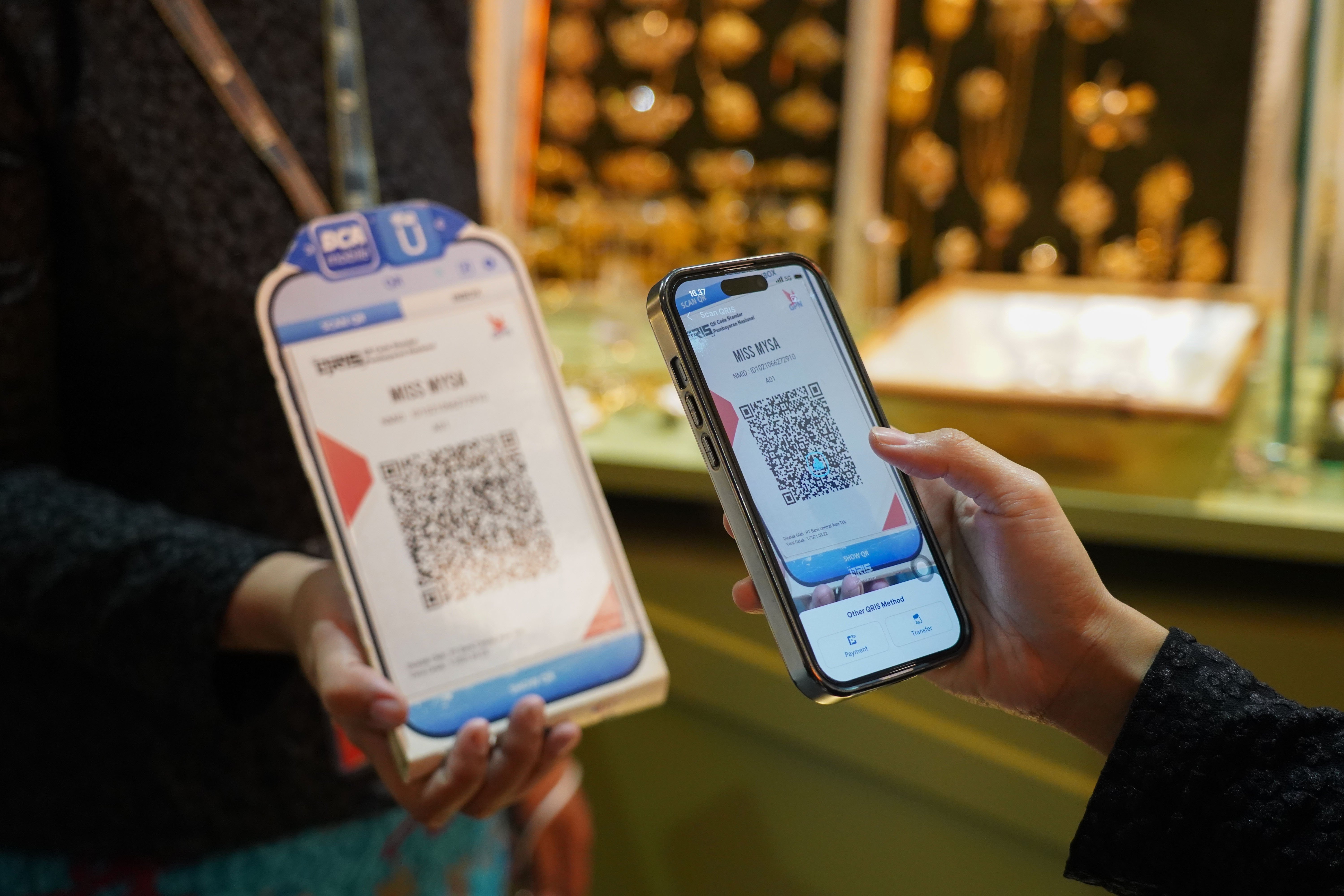 Pengunjung memindai kode batang pembayaran nontunai Quick Response Code Indonesia Standar (QRIS) saat melakukan transaksi pembelian produk pada Pameran Karya Kreatif Indonesia di Jakarta International Convention Center, Kamis (20/8/2026). Bank Indonesia (BI) memperluas MDR QRIS 0% untuk transaksi hingga Rp 100 ribu bagi seluruh kategori merchant yang akan berlaku mulai 1 Oktober 2026.
