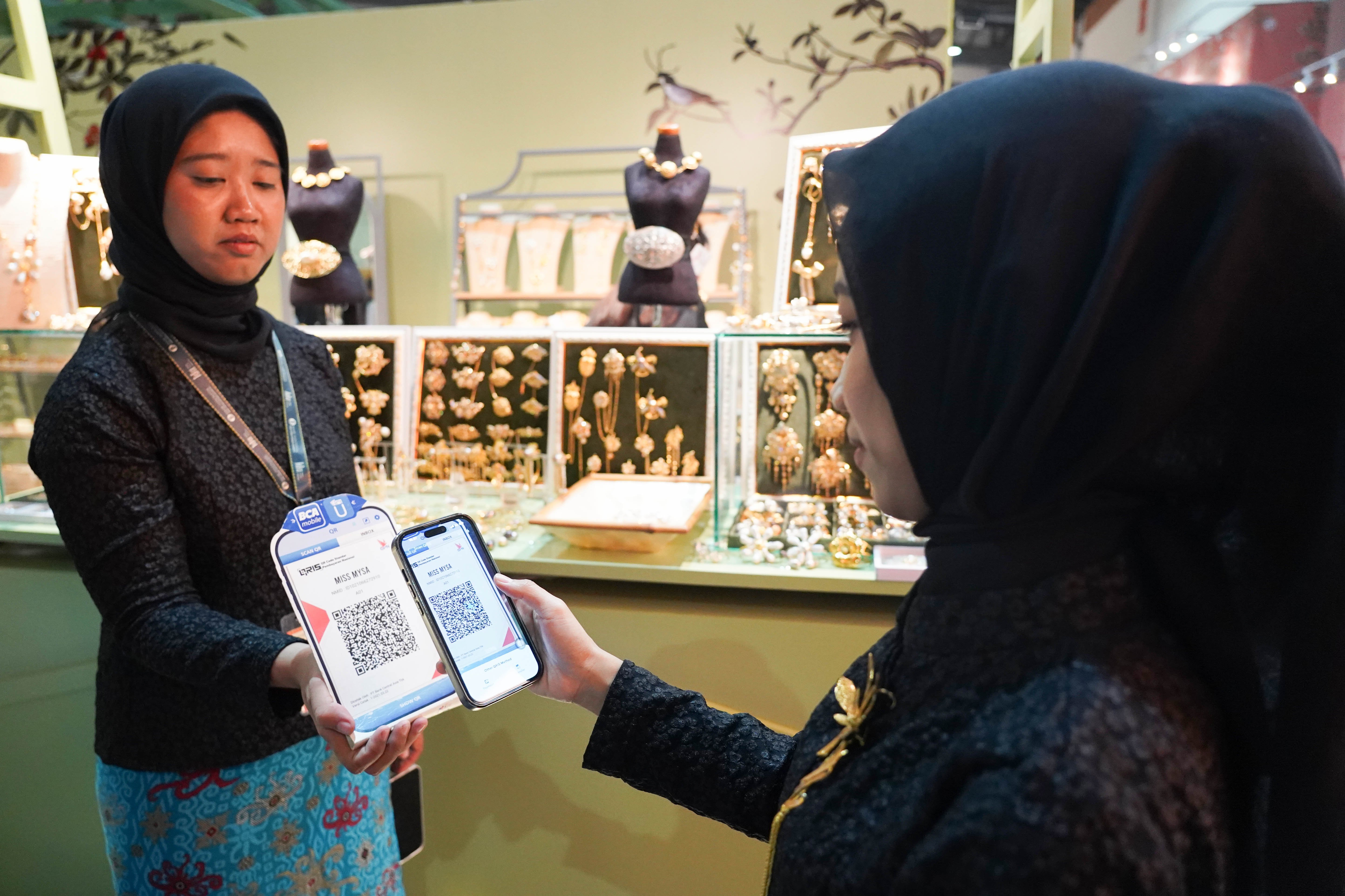 Pengunjung memindai kode batang pembayaran nontunai Quick Response Code Indonesia Standar (QRIS) saat melakukan transaksi pembelian produk pada Pameran Karya Kreatif Indonesia di Jakarta International Convention Center, Kamis (20/8/2026). Bank Indonesia (BI) memperluas MDR QRIS 0% untuk transaksi hingga Rp 100 ribu bagi seluruh kategori merchant yang akan berlaku mulai 1 Oktober 2026.